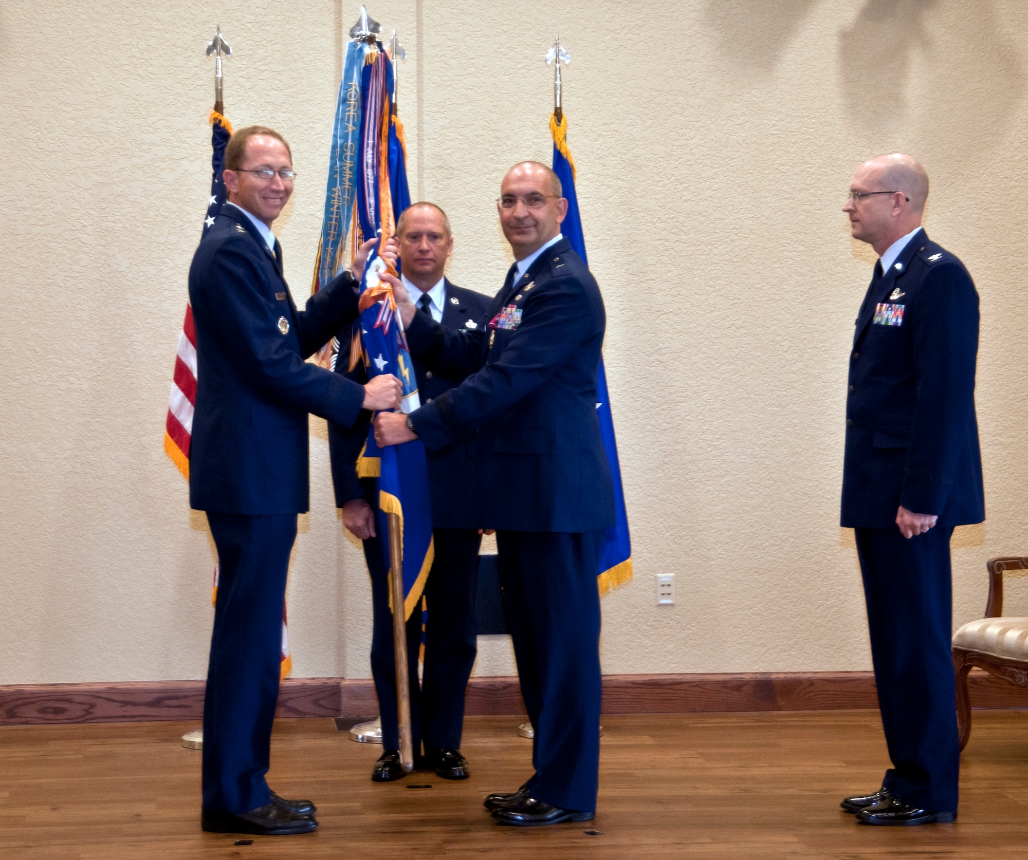 Brig. Gen. James Muscatell, 403rd Wing commander, passes the 403rd Wing guidon to Maj. Gen. James Rubeor, 22nd Air Force commander, in a change of command ceremony held here May 12 at the Bay Breeze Event Center.  General Muscatell has commanded the 403rd Wing since January 2009 and accepted a position at Scott Air Force Base, Ill.  He relinquishes command to Col. Jay Jensen, who previously served in the 403rd Wing from April 1999 to July 2008.  (U.S. Air Force photo by Tech. Sgt. Tanya King)