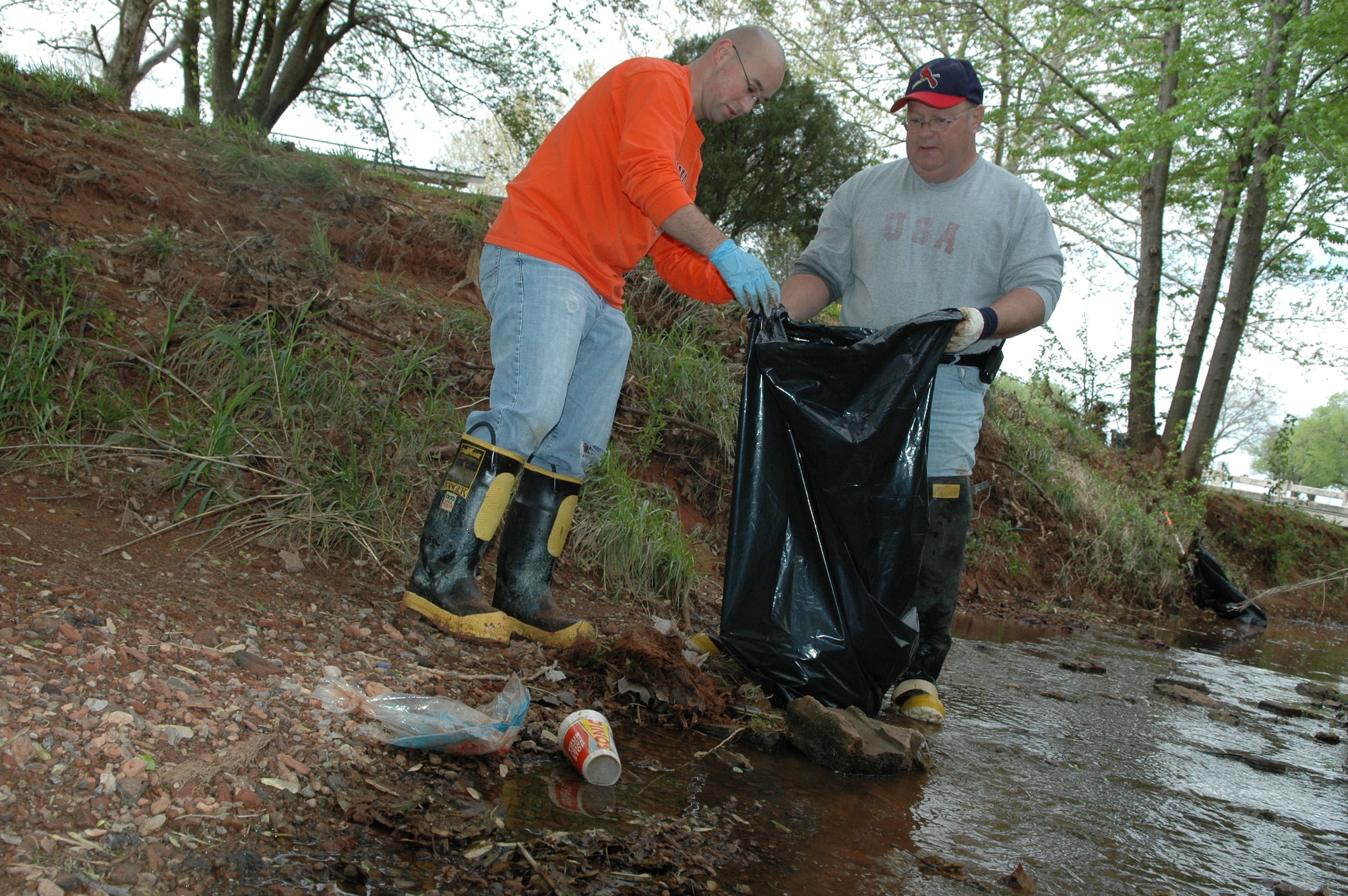 Volunteers remove trash from a Tinker creek during a recent cleanup effort sponsored by the 72nd Air Base Wing Civil Engineer Directorate. Col. Bob LaBrutta, 72nd Air Base Wing and installation commander, has designated today as a Tinker Pride Day. Organizations are being asked to hold clean up efforts across base. (Air Force photo by Brion Ockenfels)