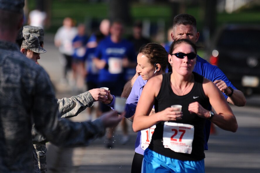 OFFUTT AIR FORCE BASE, Neb.- Runners get a drink of water as they move along General's Row on the historic parade grounds here during the 4th Annual Bellevue-Offutt Runway Run held May 8. Nearly 200 runners of all ages came to Bellevue to compete. U.S. Air Force Photo by Josh Plueger (released)
