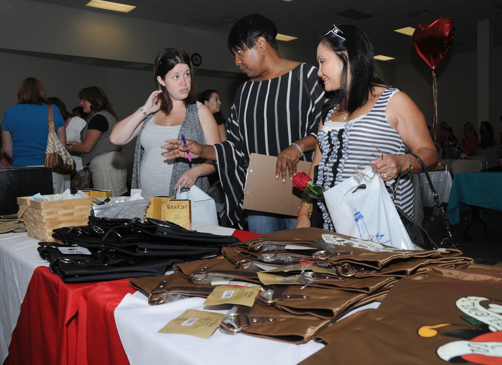 From left, Nicole Brooks, Pamela Walker and Ofelia Kozuma check out a display of products from the base exchange during Friday's Pamper Me Day at the Roberts Consolidated Aircraft Maintenance Facility.  Mrs. Brooks is married to Airman Jonathan Brooks, a student in the 338th Training Squadron; Ms. Walker is softline manager at the exchange; and Mrs. Kozuma is married to Carl Kozuma, a retired Sailor from Gulfport.  Pamper Me Day is an annual observance sponsored by the airman and family readiness center that coincides with Military Spouse Appreciation Day. The event offered refreshments, door prizes, displays and services such as manicures, massages and facials.  (U.S. Air Force photo by Kemberly Groue