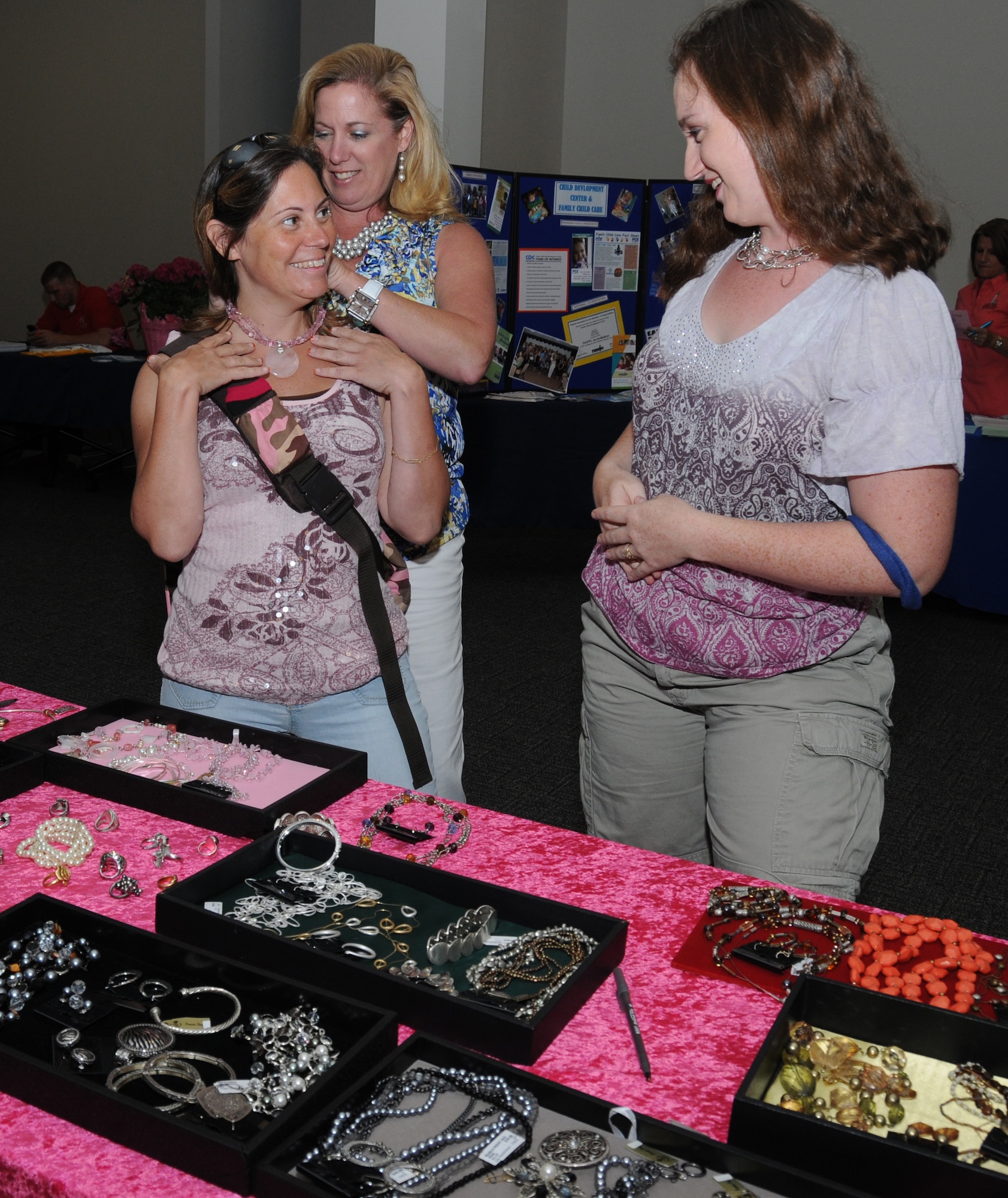 Bernadette Clark, left, gets some help with a necklace from jewelry stylist Lisa
Hendrickson as Lindy Sheely admires the accessory during Friday’s Pamper Me Day at the Roberts Consolidated Aircraft Maintenance Facility. Mrs. Clark’s husband is Maj. James Clark, 81st Security Forces Squadron commander. Mrs. Sheely is married to Staff Sgt. Grant Sheely, 81st Medical Operations Squadron. Pamper Me Day is an annual observance sponsored by the airman and family readiness center that coincides with Military Spouse Appreciation Day. The event offered refreshments, door prizes, displays and services such as manicures, massages and facials.  (U.S. Air Force photo by Kemberly Groue