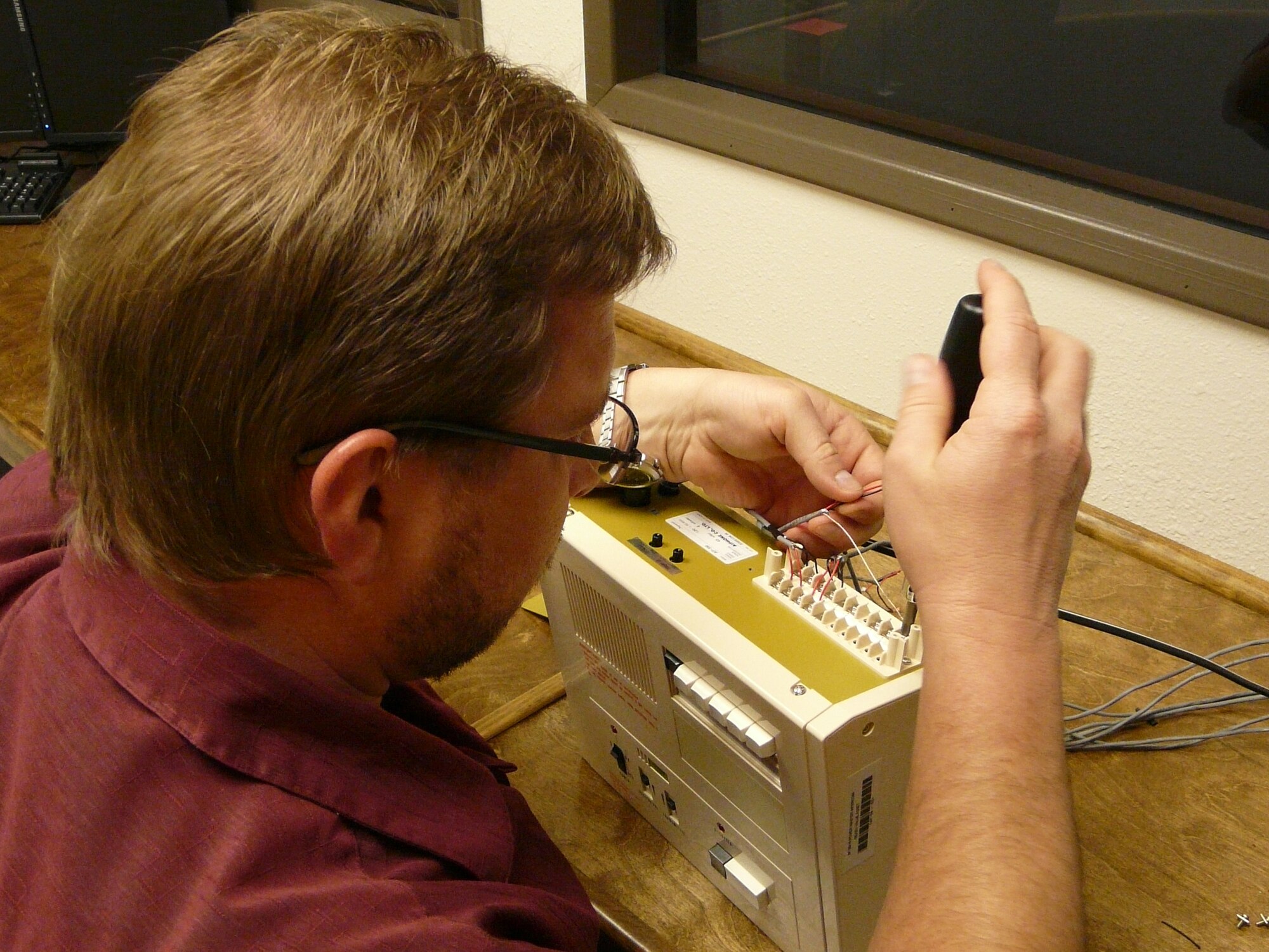 Rob Cowan, 81st TRSS, puts the final touches on the intercom and simulated
radio station system at Vandenberg.  (U.S. Air Force photo by Roger Toney)