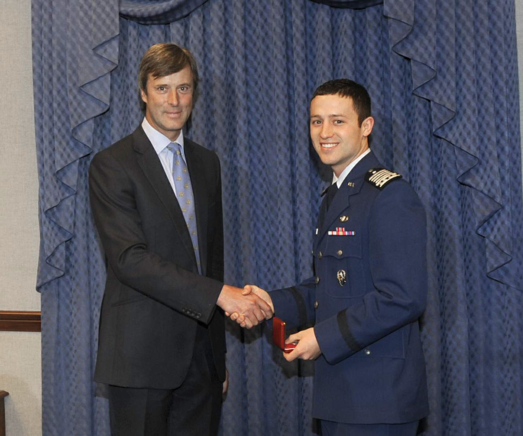 Marcus De Ferranti presents a gift to Air Force Academy Cadet Christopher J. McCool during a ceremony May 12, 2011, at the Pentagon. The ceremony was held to honor Cadet McCool, the 2010 U.S. Air Force Cadet of the Year. Mr. Ferranti was representing the Air Squadron, a private British organization that established the award in 2000 to pay tribute to the U.S. military for its support of the United Kingdom over the years. (U.S. Air Force photo/Andy Morataya)
