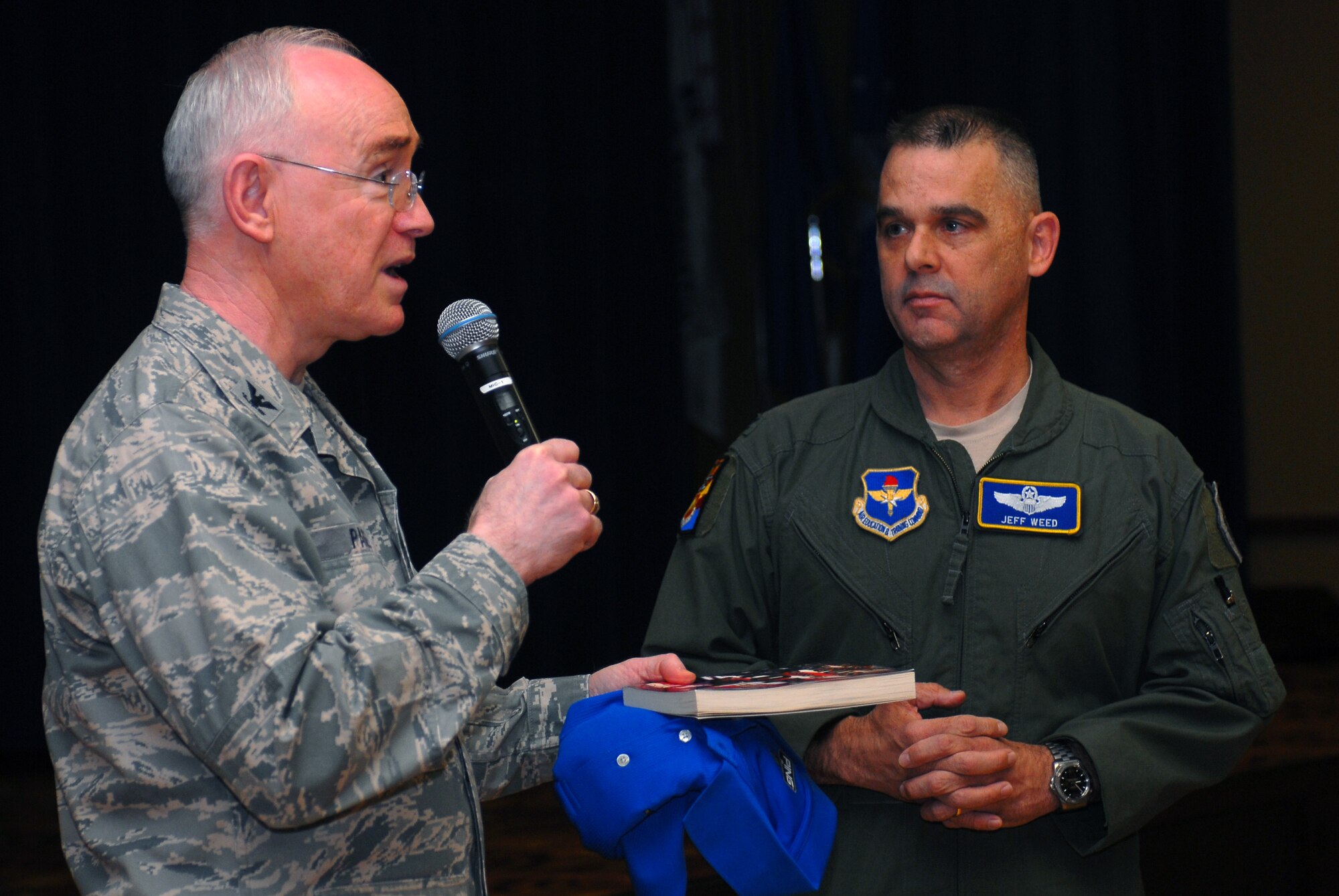 Col. Bobby Page, Air Education and Training Command chaplain, presents Col. Jeff Weed, 56th Fighter Wing vice commander, with a book May 5 during the 2011 National Prayer Breakfast at Luke Air Force Base.  The book, "Days of Anguish, Days of Hope," is a biography about the life of Chaplain Robert Preston Taylor, a prisoner of war during World War II.  (U.S. Air Force photo by Senior Airman Tracie Forte)