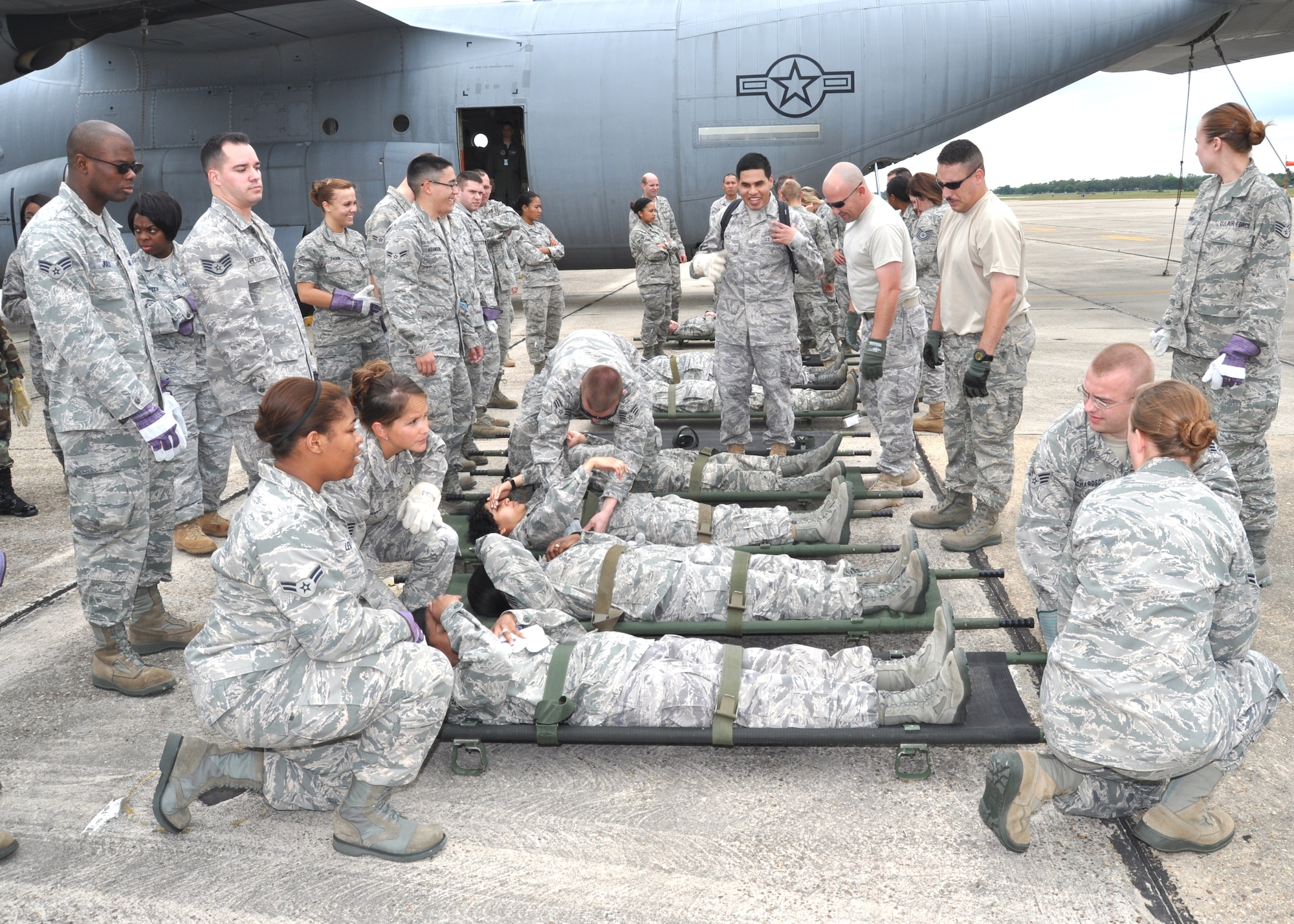 Litter team members from the 81st MDG prepare to carry “patients” to a waiting 403rd Wing C-130J Hercules during an April 14 exercise. Almost 80 medics from a variety of specialties trained to load and unload litter patients on the aircraft.  The monthly warrior training also included moving patients on and off an ambulance and ambus. The session was conducted to prepare for next week’s Ultimate Caduceus 2011 national disaster exercise. Keesler and other area hospitals will be heavily involved Wednesday.  (U.S. Air Force photo by Steve Pivnick)