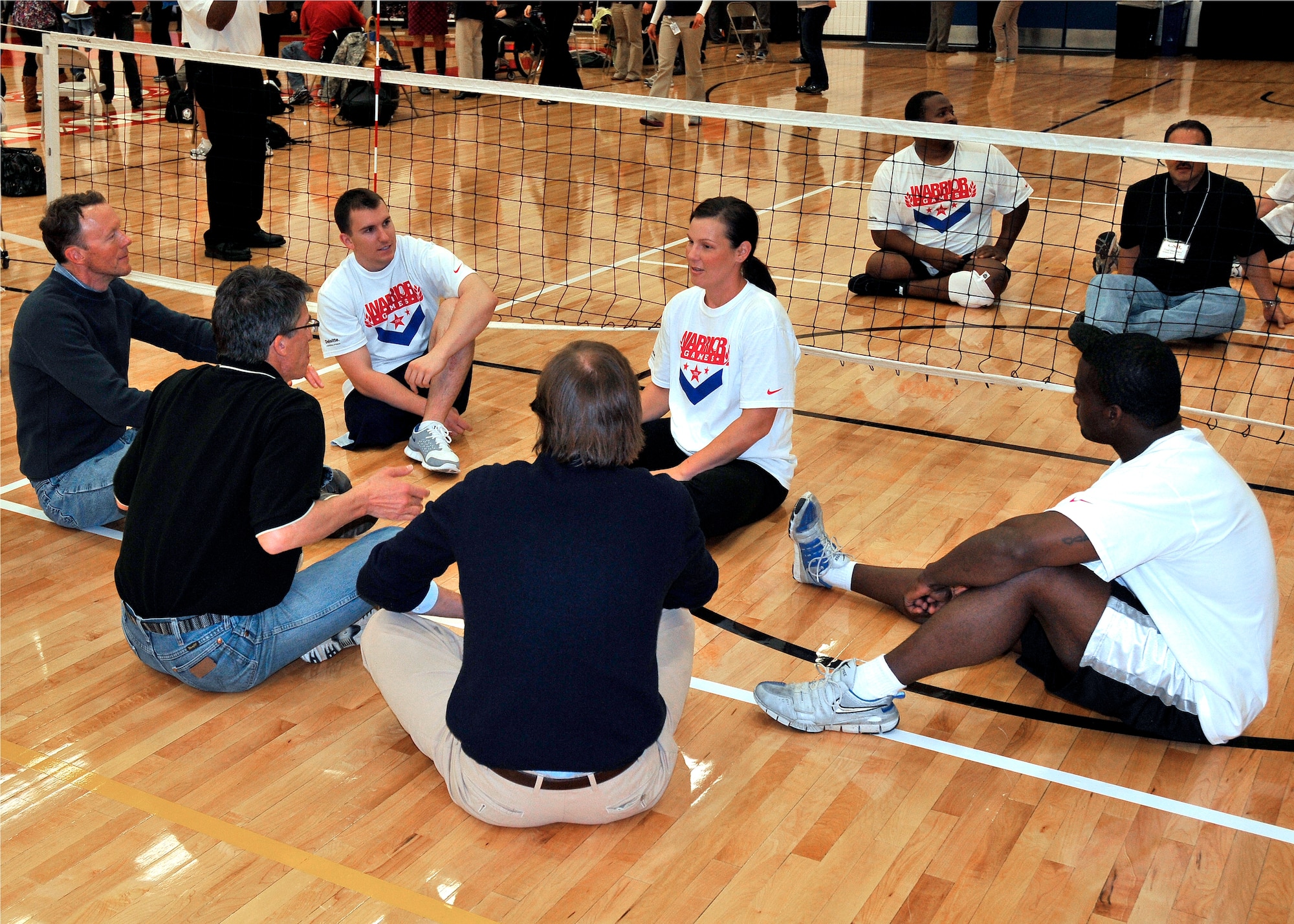 Stacy Pearsall, a retired staff sergeant (center) explains the rules and strategies of sitting volleyball to Colorado Springs area civic leaders while team mates Matthew Pirrello, an Ohio University ROTC cadet (left) and Matt Sanders, a retired staff sergeant (right) listen in. The three are competitors in the 2011 Warrior Games. (U.S. Air Force Photo by Lt.Col. Richard Williamson.)