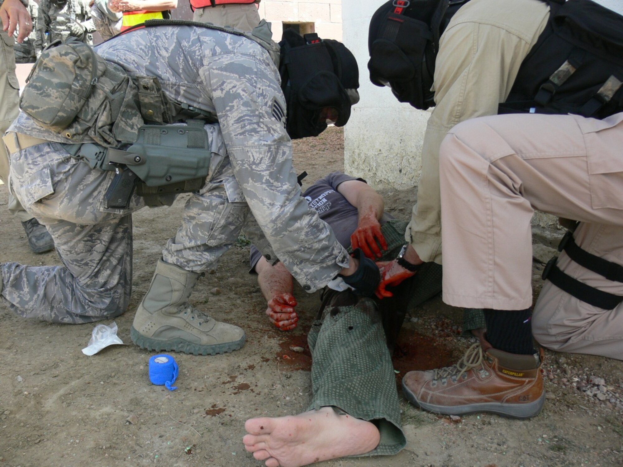 An Airman and a Department of Defense police officer provide medical care to an “injured” person during an Active Shooter Instructor Course, which included Airmen and DoD police from the 21st Security Forces Squadron. Airmen and DoD police from six other squadrons in Air Force Space Command also participated in the training, held May 2- 5 at Fort Carson Army Installation’s Range 60. Security forces personnel participated in a five-day, 48-hour training Active Shooter Instructor training course with the goal of going back to their individual squadrons to provide on-going training and preparation in the event that a shooter enters a base installation. (U.S. Air Force photo/Monica Mendoza)