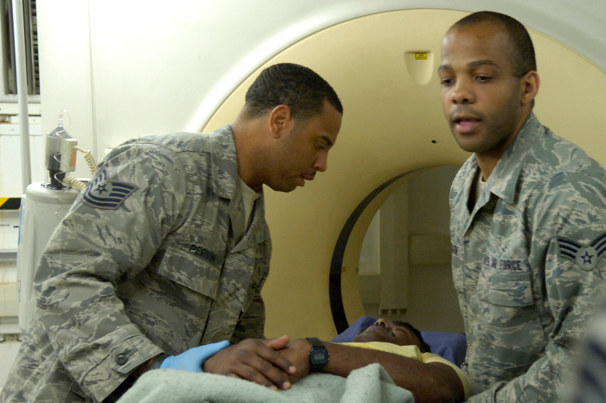 KIRKUK REGIONAL AIR BASE, Iraq - Tech. Sgt. Eric Person, left, 321st Expeditionary Medical Squadron radiology technician, and SrA Stephen Leysath, 321st Expeditionary Medical Squadron aerospace medical technician, move a patient into place for a computed axial tomography scan. The 321st EMEDS is the principal surgical unit for American forces in all of northern Iraq, treating military and civilian patients alike. Sergeant Person, originally from Phenix City, Ala., is deployed from Eglin Air Force Base, Fla. Airman Leysath is originally from Neptune, N.J., and also deployed from Eglin AFB. (U.S. photo by Tech. Sgt. Randy Redman)