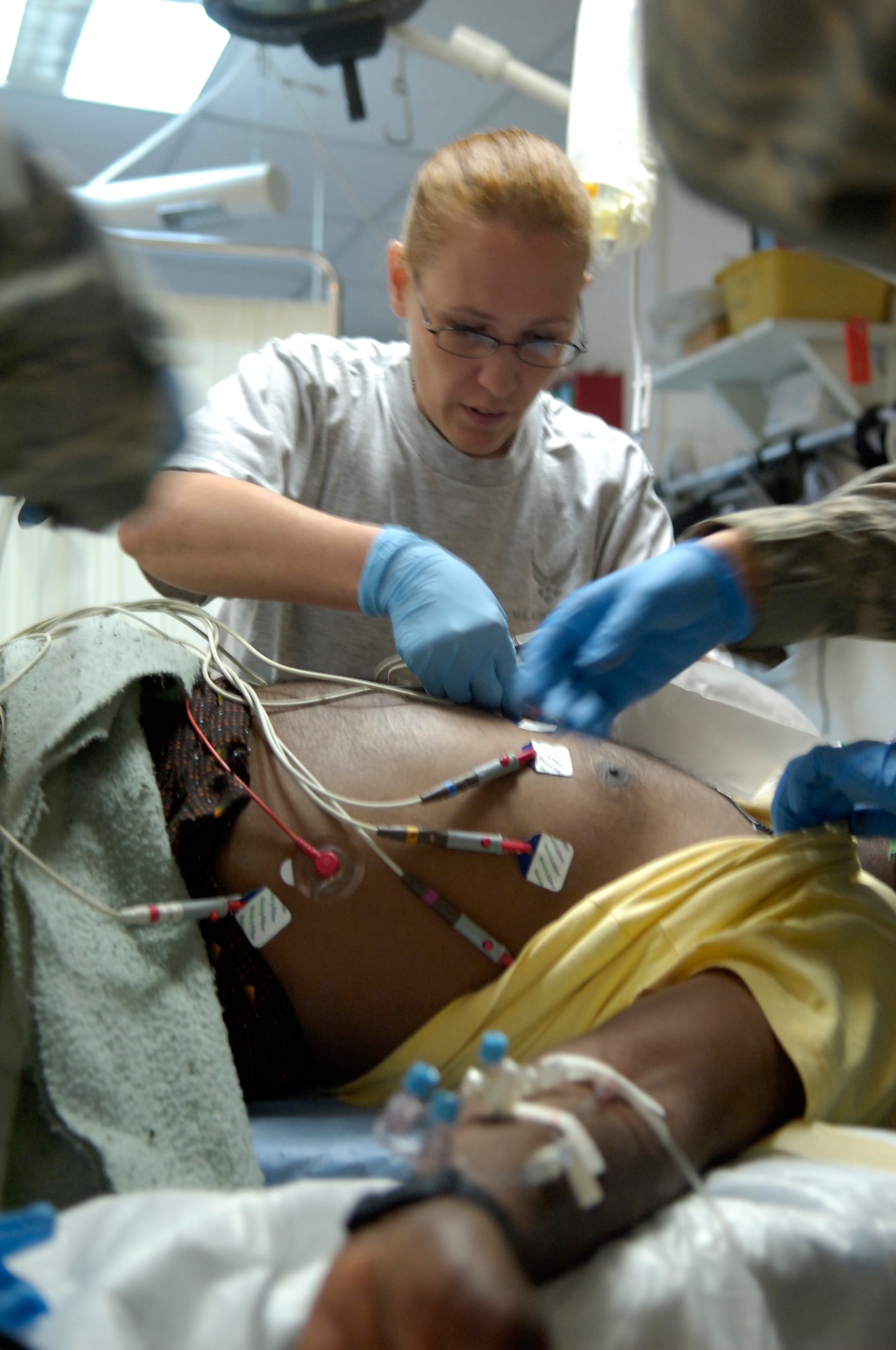 KIRKUK REGIONAL AIR BASE, Iraq – 1st Lt. Stephanie Englmeier, 321st Expeditionary Medical Squadron operating room nurse, attaches electrodes to a patient’s chest to check for vital signs May 11. The 321st EMEDS is the principal surgical unit for American forces in all of northern Iraq, treating military and civilian patients alike. Lieutenant Englmeier, originally from Augres, Mich., is on her first-ever deployment from Eglin Air Force Base, Fla. (U.S. photo by Tech. Sgt. Randy Redman)