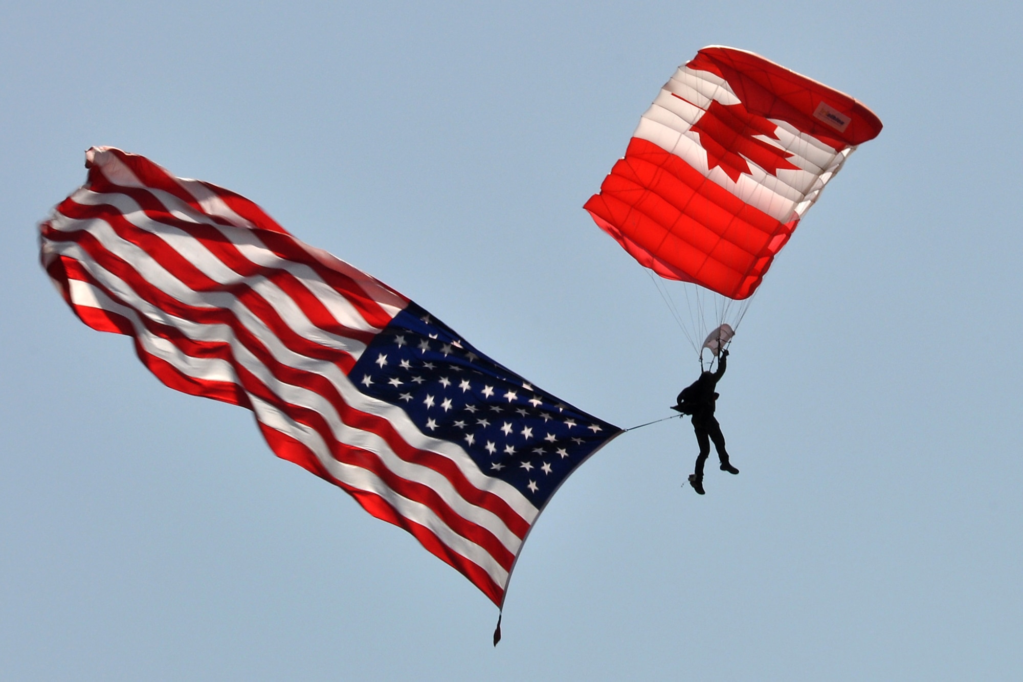 Sergeant Ray Baril, who is member of the Canadian Forces Parachute Demonstration Team “Skyhawks,” parachutes into the drop zone with the American Flag during opening ceremonies at the 2011 Defenders of Liberty Air Show on Barksdale Air Force Base, La., May 7, 2011. Both the 307th Bomb Wing and 917th Fighter Group provided static displays for the air show. (U.S. Air Force photo/Tech. Sgt. Jeff Walston)