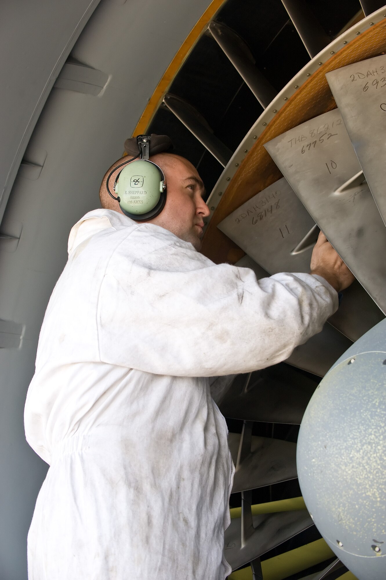 Staff Sgt. Rob Sheppard, 436th Aircraft Maintenance Squadron flying crew chief, inspects the blades of a TF-39 engine on a C-5B Galaxy May 12, 2011, at Dover Air Force Base, Del. Sergeant Sheppard is wearing a special suit to prevent any foreign debris from entering the engine’s systems.  (U.S. Air Force photo by Airman 1st Class Jacob Morgan)