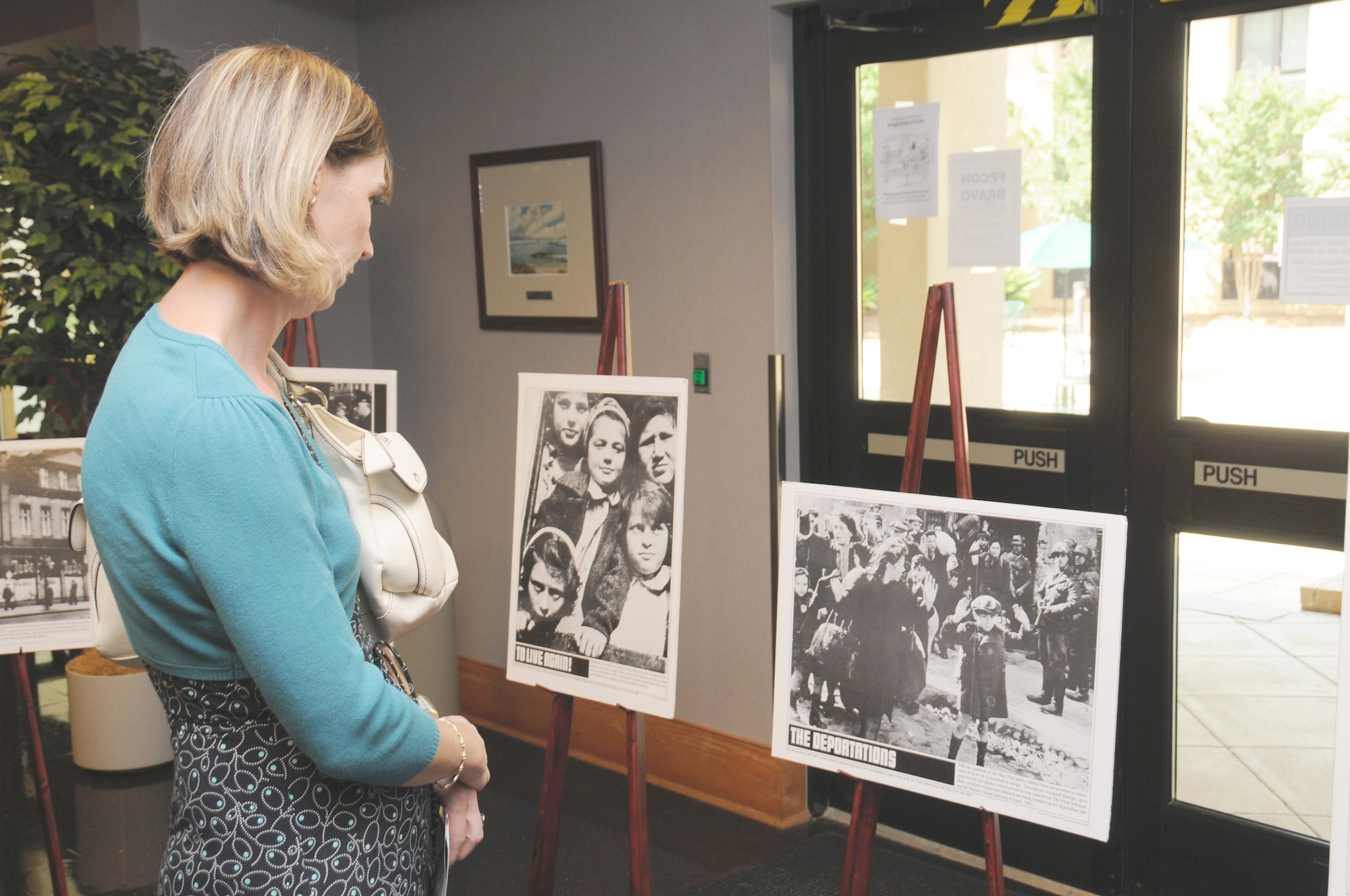 Nadega Soubassis looks at Holocaust-era photos on display in the Husband Auditorium lobby Tuesday (Air Force photo/Chris Baldwin).