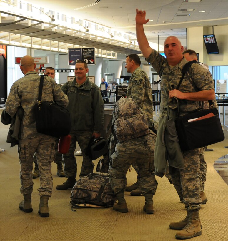 An Airman from the Kentucky Air National Guard 123d Civil Engineers Squadron, Louisville, Ky., waves goodbye as several members of the unit depart Louisville International Airport for Afghanistan Dec. 8, 2010.  The Airmen will be supporting airbase operations at an undisclosed location during a six-month tour of duty.  (U.S. Air Force photo by Tech. Sgt. Dennis Flora)