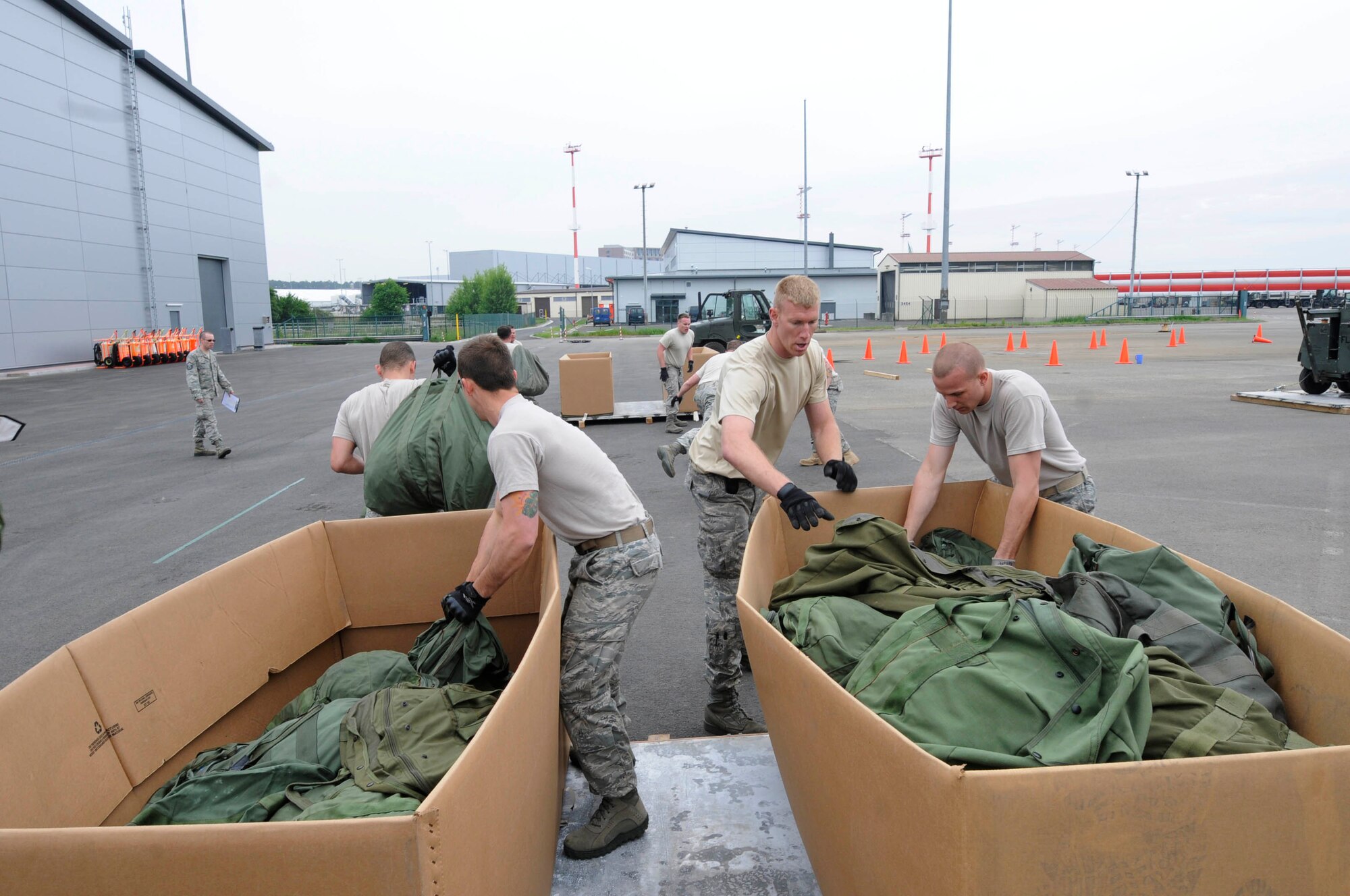 U.S. Air Force Airmen from the 435th Air Mobility Squadron and the 86th Logistics Readiness Squadron move baggage from one bin to another bin approximately 30 meters away during a Mini Rodeo Challenge, Ramstein Air Base, Germay, May 12, 2011. The purpose of the Mini Rodeo Challenge is to determine which team will be competing for points on behalf of Team Ramstein at the Air Mobility Command Airlift Rodeo in July 2011. (U.S. Air Force photo by Airman Kendra Alba)