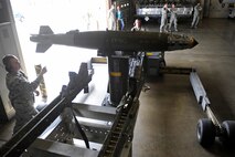 Senior Airman Timothy Branco observes as Airman 1st Class Thomas Prusso transports a GBU-38 joint direct attack munition on an MHU-83 bomb lift truck during Spouse Appreciation Day at Ellsworth Air Force Base, S.D., May 6, 2011.  Airmen Branco and Prusso are armament specialists assigned to the 28th Aircraft Maintenance Squadron. (U.S. Air Force photo/Staff Sgt. Marc I. Lane)