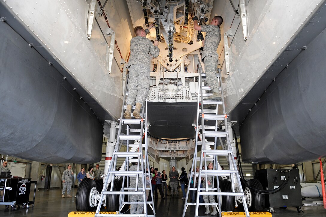 Staff Sgt. Richard Lewis (left) and Airman 1st Class Thomas Prusso, 28th Aircraft Maintenance Squadron armament specialists, demonstrate how to prepare the bomb racks in the aft bay of a B-1B Lancer armament systems trainer during Spouse Appreciation Day at Ellsworth Air Force Base, S.D., May 6, 2011.  Approximately 150 Ellsworth spouses came together to participate in a wide array of activities designed to thank them for all they do and the important role they play in the lives of their Airmen. (U.S. Air Force photo/Staff Sgt. Marc I. Lane)