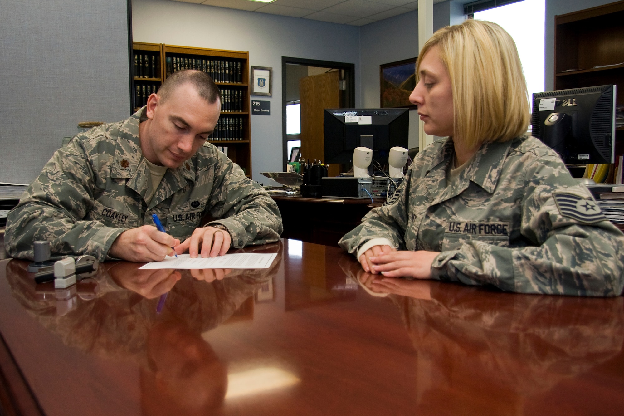 GRISSOM AIR RESERVE BASE, Ind. -- Maj. Matt Coakley, 951st Reserve Support Squadron staff judge advocate, signs a power of attorney for Tech. Sgt. Misty McKinney, 434th Maintenance Group client support administrator, April 20. Major Coakley was recently awarded the Air Force Reserve Command 2010 Albert M. Kuhfeld Award for Outstanding Judge Advocate. The award recognizes the regular Air Force officer in the grade of major or captain selected as the most outstanding judge advocate of the year based on demonstrated excellence, initiative and devotion to duty. In his role as the 951st RSS SJA, he provides legal advice and support to over 7,500 Department of Defense military and civilian personnel. (U.S. Air Force photo/Tech. Sgt. Mark R. W. Orders-Woempner) 
