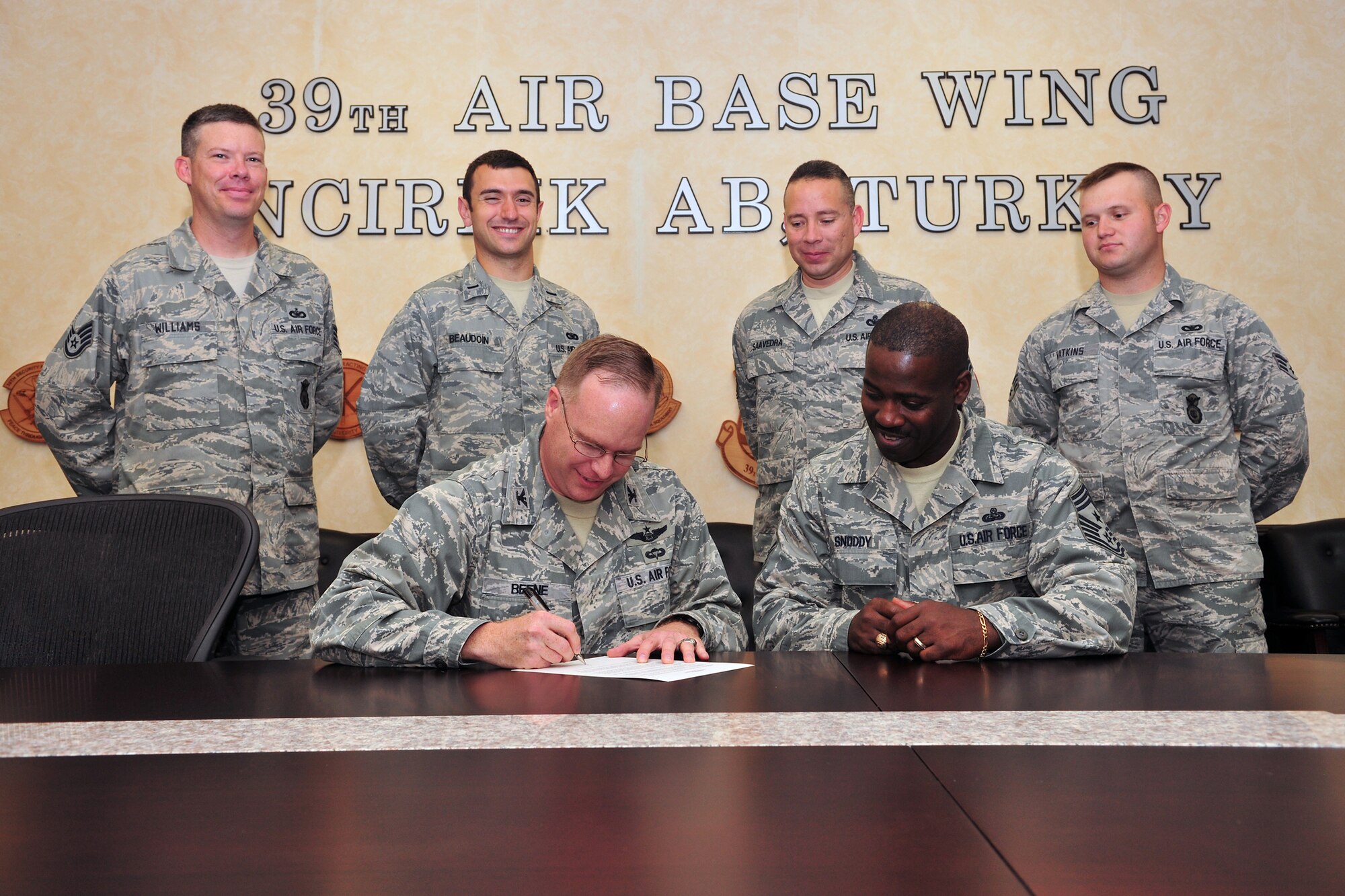 Col. Eric Beene, the 39th Air Base Wing commander, signs the National Police Week proclamation as 1st Lt. Daniel Beaudoin, from the 39th Security Forces Squadron, and members of the 39th SFS look on, May 6, 2011.  The proclamation signing will help begin a week’s worth of informational activity to help the community celebrate and support our nation’s military and civilian police men and women. (U.S. Air Force photo by Staff Sgt. Alexandre Montes/Released)