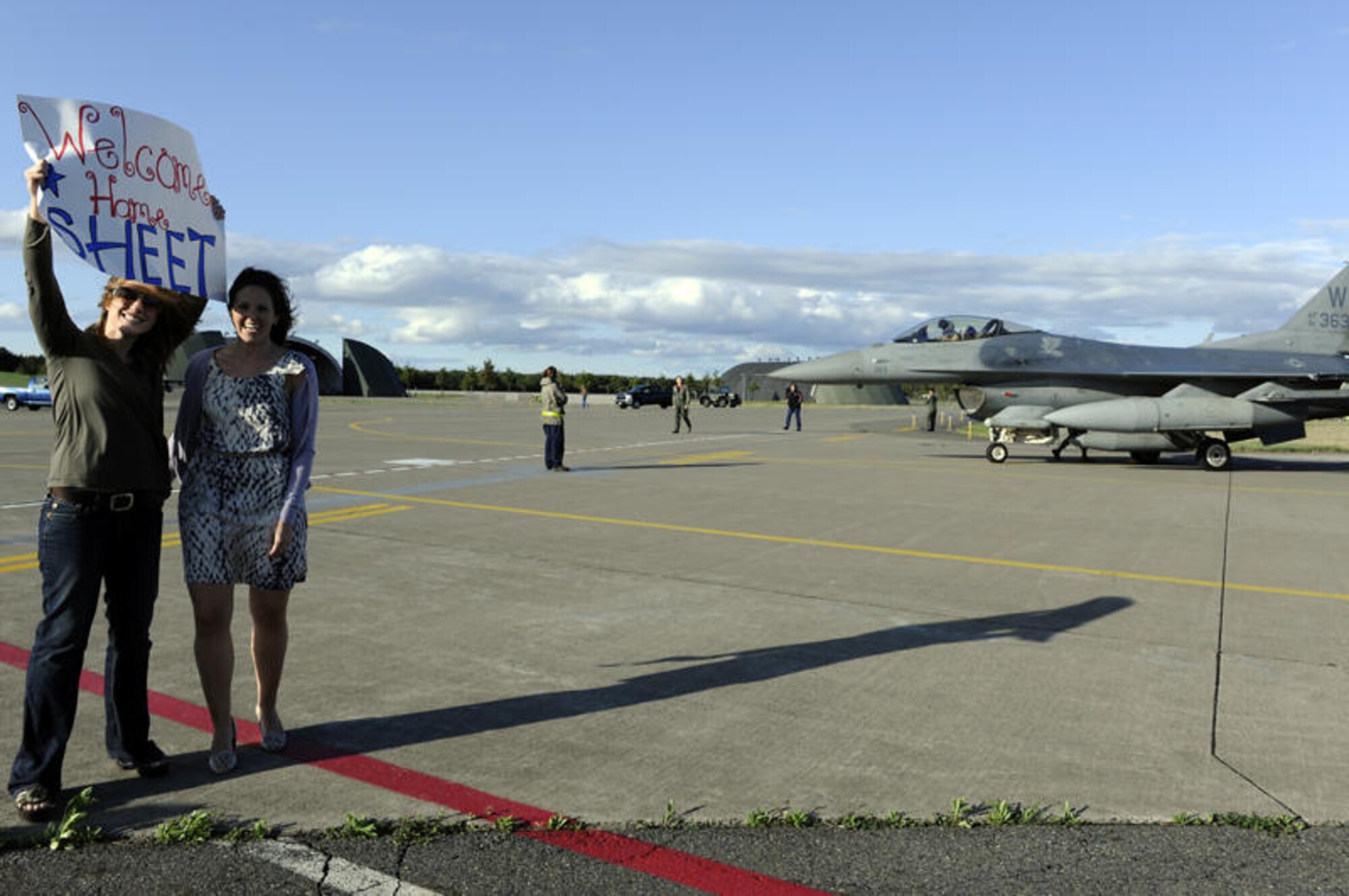 MISAWA AIR BASE, Japan -- Laura Breau, wife of Capt. Jesse Breau, 13th Fighter Squadron pilot, left, helps Danielle Hoyt welcome home her husband, Capt. Matt Hoyt, 13th FS pilot, May 13. Members of the 13th FS have been returned home from deployment throughout the past week. (U.S. Air Force photo/Staff Sgt. Marie Brown/Released)