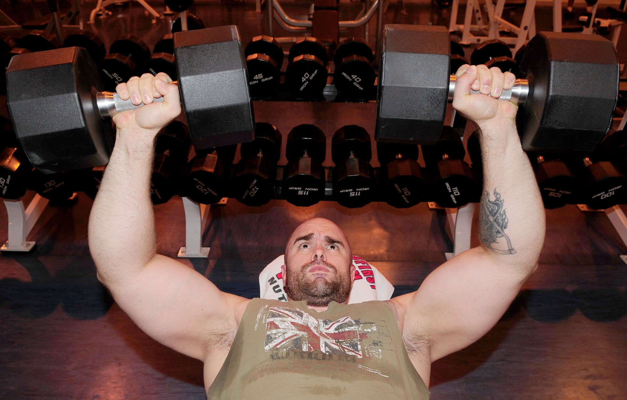 RAF MILDENHALL, England -- Staff Sgt. Jason Cravens, 727th Air Mobility Squadron, uses a pair of weights to perform chest presses at the North Side Fitness Center here May 12, 2011. When lifting weights, it is best to not over lift, to help prevent injuries and to allow good form according to Talli van Sunder, exercise columnist. (U.S. Air Force photo/Senior Airman Ethan Morgan)