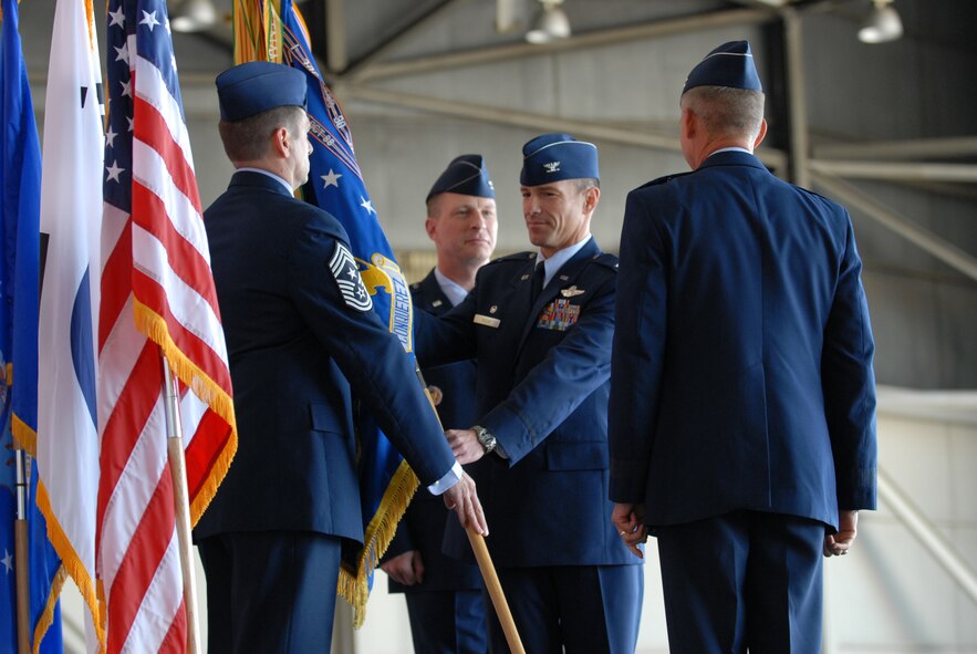 KUNSAN AIR BASE, Republic of Korea – Col. Scott Pleus, 8th Fighter Wing commander, returns the wing guidon to Chief Master Sgt. Scott Delveau, 8th FW command chief, as Col. John Dolan, former 8th FW commander, and Lt. Gen. Jeffrey Remington look on during the change of command ceremony here May 13.   General Remington, the Deputy Commander, United Nations Command Korea; Deputy Commander, U.S. Forces Korea; Commander, Air Component Command, Republic of Korea; U.S. Combined Forces Command; and 7th Air Force commander, presided over the ceremony. (U.S. Air Force photo/Master Sgt. Sonny Cohrs)
