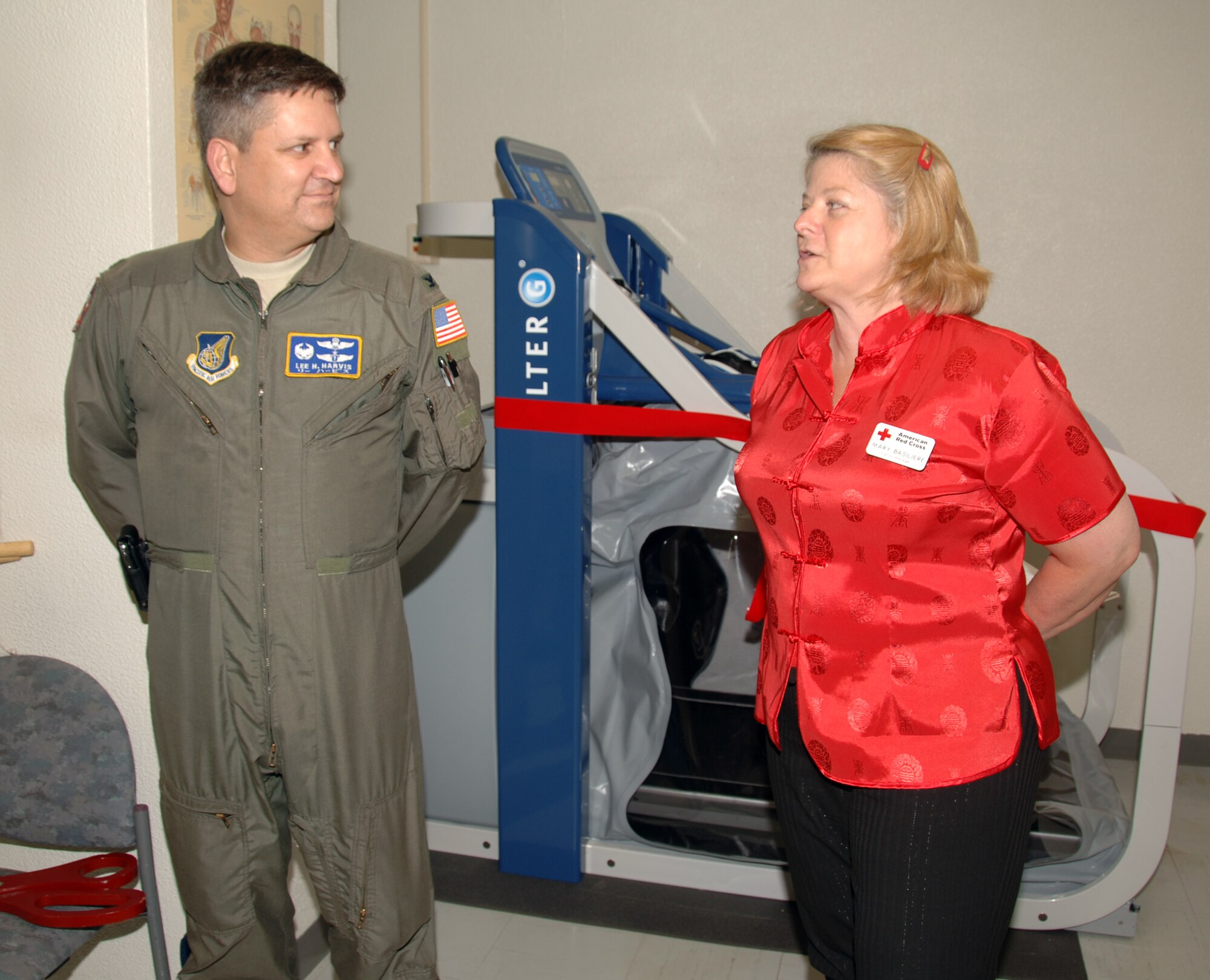 YOKOTA AIR BASE, Japan - Col. Lee Harvis, 374th Medical Group commander (left), and Mary Basiliere, American Red Cross senior station manager, explain the importance of the newest addition to the physical therapy department during a ribbon cutting ceremony held at the physical therapy clinic Yokota Air Base, Japan May 11, 2011. The AlterG Zero-Gravity Treadmill will help patients recover in rehabilitation following injury or surgery of the lower extremities. (U.S. Air Force Photo/Airman 1st Class Katrina R. Menchaca)