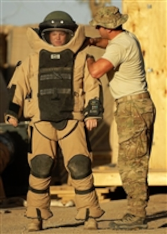 U.S. Air Force Staff Sgt. James Weber (right), an explosive ordnance disposal technician with the 11th Civil Engineer Squadron, assists Staff Sgt. Amber Goedde, an EOD technician with the 23rd Civil Engineer Squadron, in donning a bomb suit at Forward Operating Base Azizullah, Afghanistan, on May 6, 2011.  