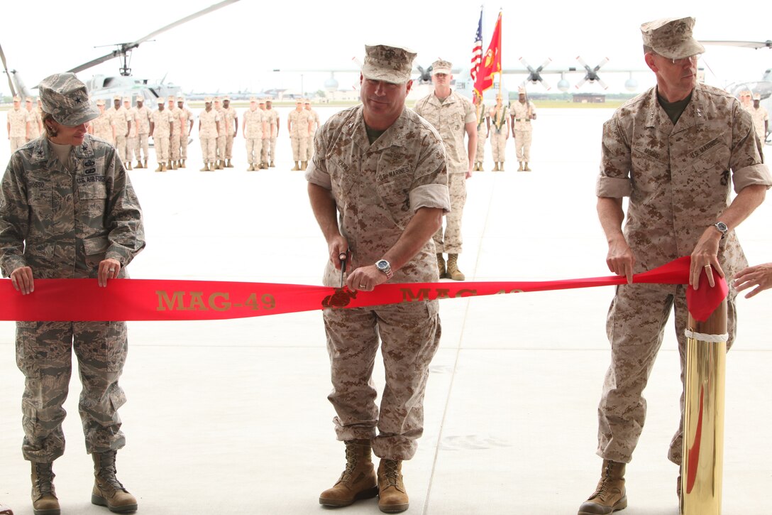 Air Force Brig. Gen. Gina Grosso, commander of Joint Base McGuire-Dix-Lakehurst, Col. Christopher Papaj, commanding officer of Marine Aircraft Group 49, and Maj. Gen. Darrell Moore, commander of Marine Forces Reserve, cut the ribbon at the ribbon cutting ceremony May 13.  They cut the ribbon to celebrate MAG-49’s relocation to their new hangar on JB MDL.
