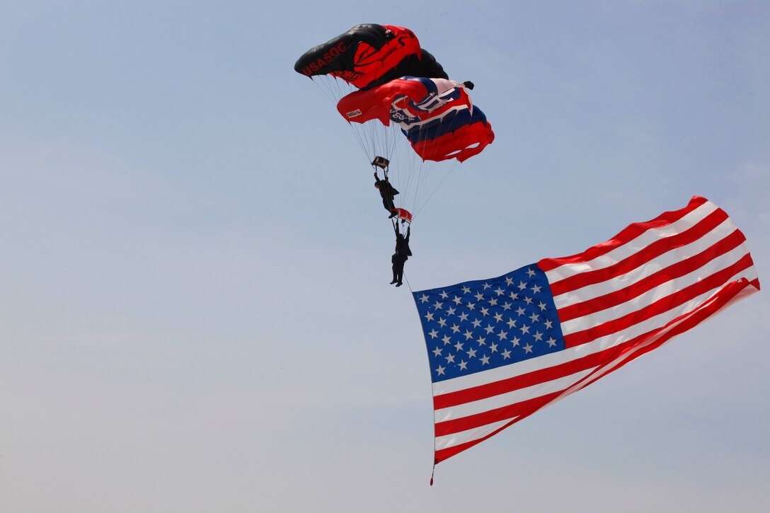 Members of the U.S. Army Special Operations Command Parachute Demonstration Team, the Black Daggers, descend upon the flightline with the American flag in tow at the opening of the 2011 Sounds of Freedom Air Show aboard Marine Corps Air Station New River, May 14.