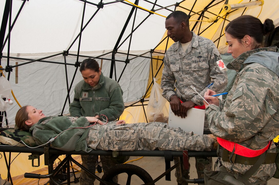 U.S. Air Force Major Lisa Seltman, 140th Medical Group, simulates a patient as fellow 140th MDG personnel 2nd Lt. Luvelle Navarro, Tech. Sgt. David Brown and Tech. Sgt. Bonnie Vega perform medical training exercises at Buckley Air Force Base Colo., May 14, 2011.  Buckley airmen are taking part in the Operational Readiness Exercise being held on base throughout the weekend. The ORE helps prepare airmen with mission readiness for real world deployments and the wings upcoming Operational Readiness Inspection next year.  (U.S. Air Force photo by Tech. Sgt. Wolfram M. Stumpf) (RELEASED)