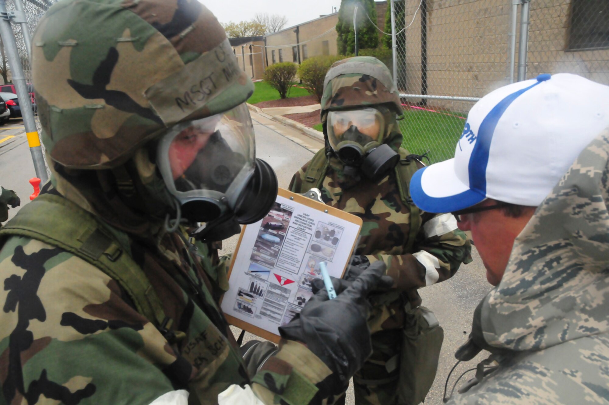 Airmen from the 128th Air Refueling Wing, Milwaukee, discuss their decisions and actions with monitoring officials during an Ability to Survive and Operate exercise at Gen. Mitchell International Airport on Saturday, May 14, 2011. The ATSO exercise tested the readiness and preparedness of Airmen to survive and operate during chemical, nuclear, and biological attacks. U.S. Air Force photo by Tech Sgt. Thomas J Sobczyk  / Released
