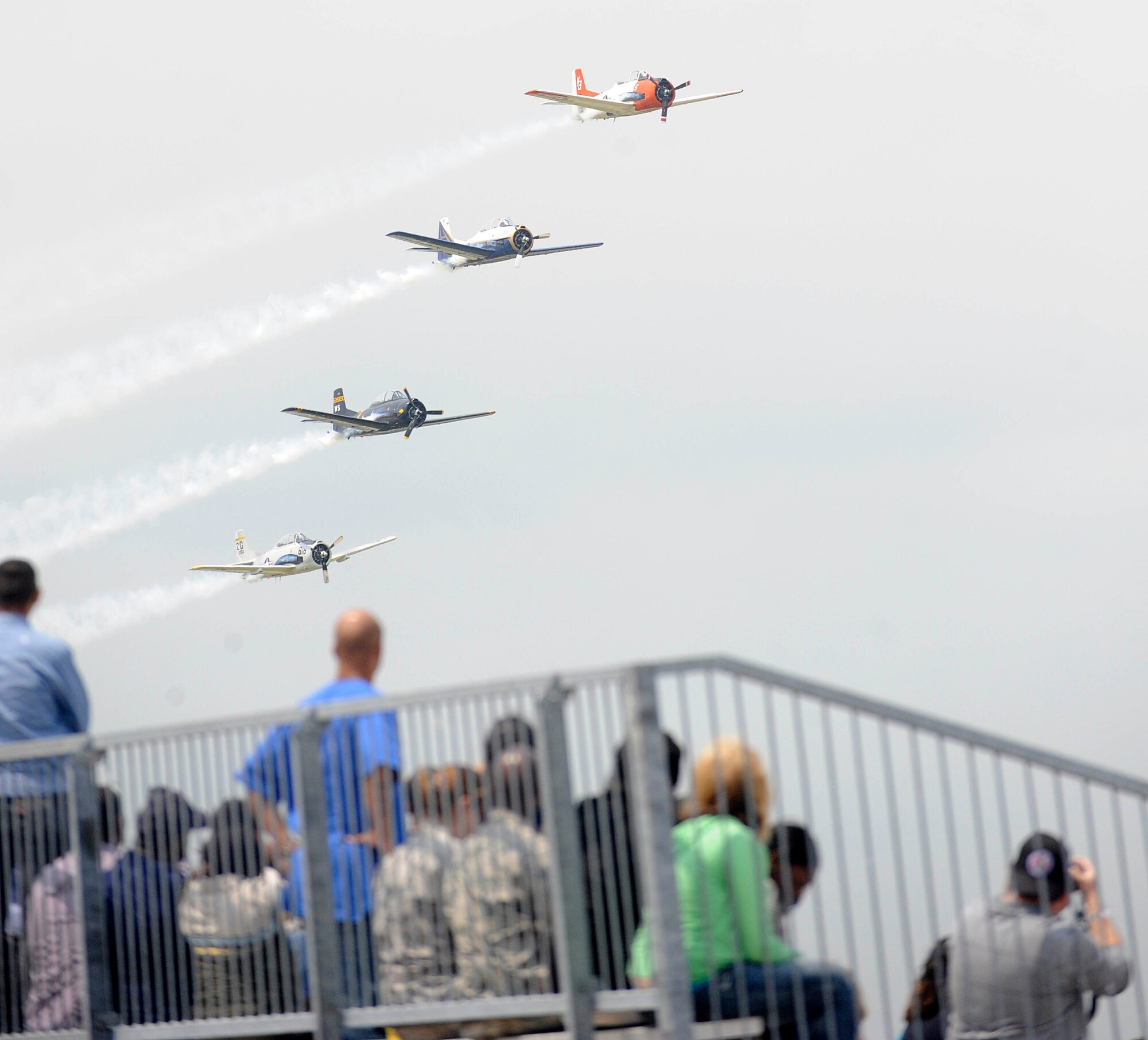 Spectators watch as the Trojan Horsemen T-28 Warbirds Aerobatic Formation Demonstration Team performs aerial maneuvers during the AirPower over Hampton Roads open house at Langley Air Force Base, Va., May 14, 2011. The open house is a free three-day event featuring aerial demonstrations by modern and historical military aircraft and civilian performers. (U.S. Air Force photo by Staff Sgt. Dana Hill)(RELEASED)