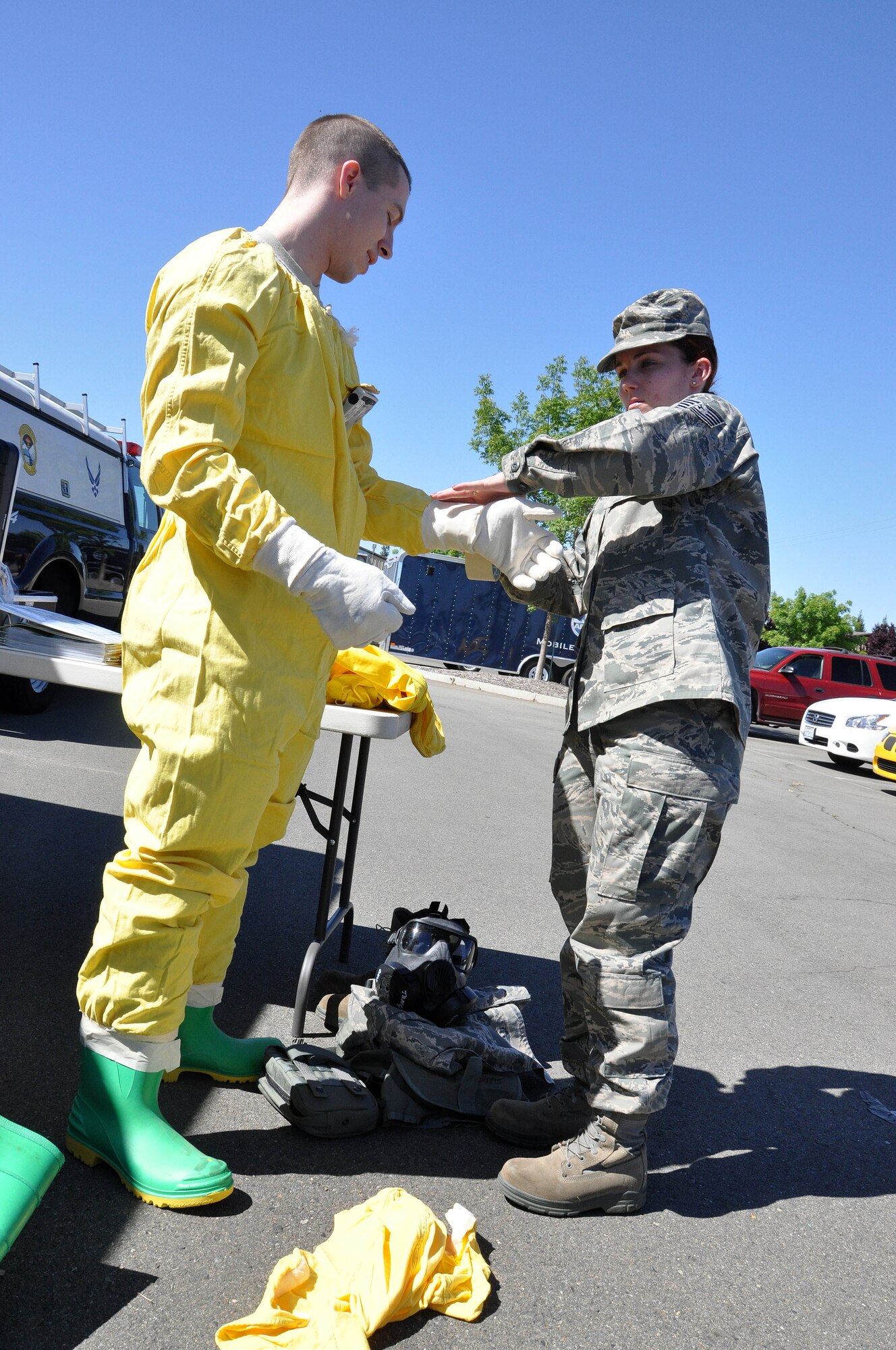 Air Force Reservist Tech. Sgt. Stephanie Chan, 940th Civil Engineer Squadron, assists an airman with donning his personal protective gear during a collaborative CE training exercise involving airmen from the 940th CES and the 9th CES, May 14. The exercise provided an excellent opportunity for reserve and active duty units to train together to become more proficient in handling an urgent situation involving a radioactive explosive device. (U.S. Air Force Photo/ Tech. Sgt. Luke Johnson)