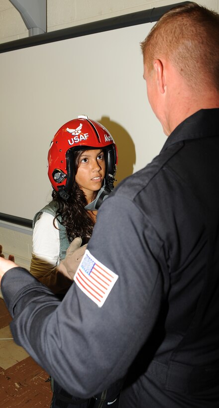 Staff Sgt. Raymond LeBlanc, Thunderbirds crew chief, explains the role of personal protective flight equipment to Hampton High School Student Guadalupe Almendarez, 16, May 13, 2011. As Air Force ambassadors, the Thunderbirds display the integrity, selfless service, and excellence embodied by American Airmen everywhere. (U.S. Air Force photo/A1C Teresa Zimmerman)(RELEASED)