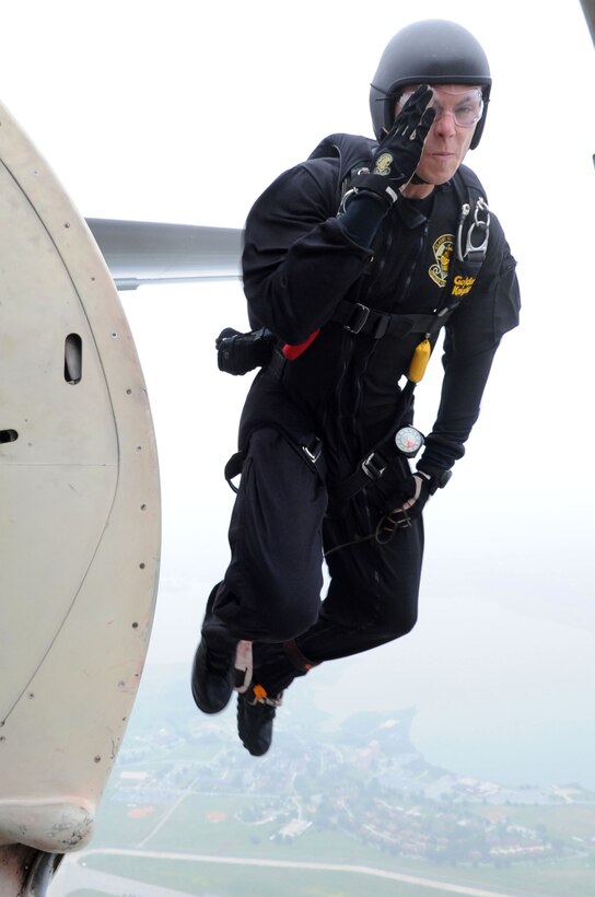 Army Spc. Jeshua Stahler, U.S. Army Golden Knights Parachute Team, parachutist, renders a hand salute as he jumps from a C-31 at Langley Air Force Base, Va., May 13, 2011. The Golden Knights have been wowing audiences at air shows, competitions, and high-profile tandems for 50 years. (U.S. Air Force photo by Airman 1st Class Kayla Newman)(RELEASED)