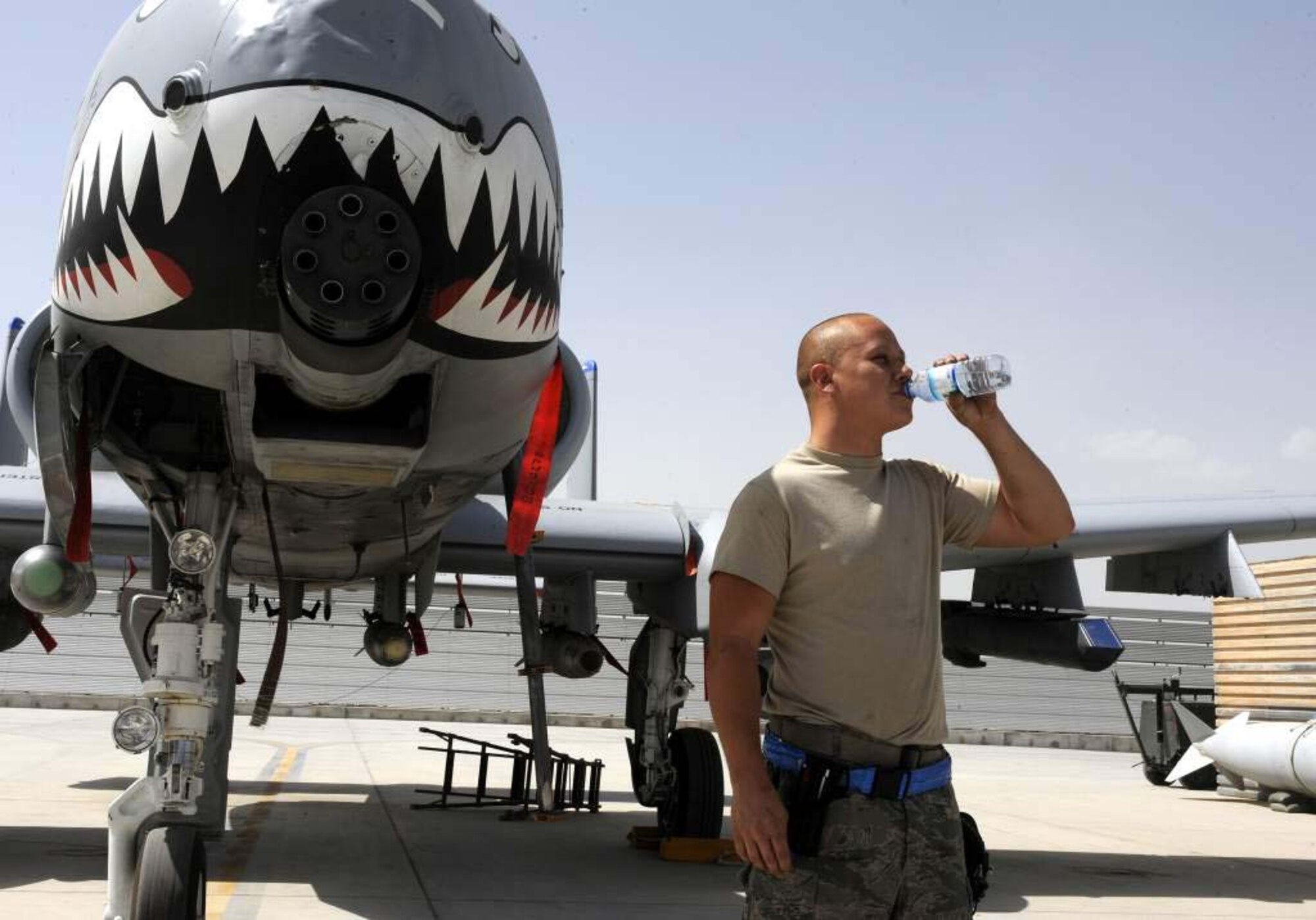 Airman 1st Class Matthew Bryant drinks water from the 451st AEW safety office at Kandahar Airfield, Afghanistan on May 13. The flightline of the airfield has been getting hotter as summer progresses. Airman Bryant is a crew chief on the A-10 Warthog. (Photo by Senior Airman Willard Grande II)