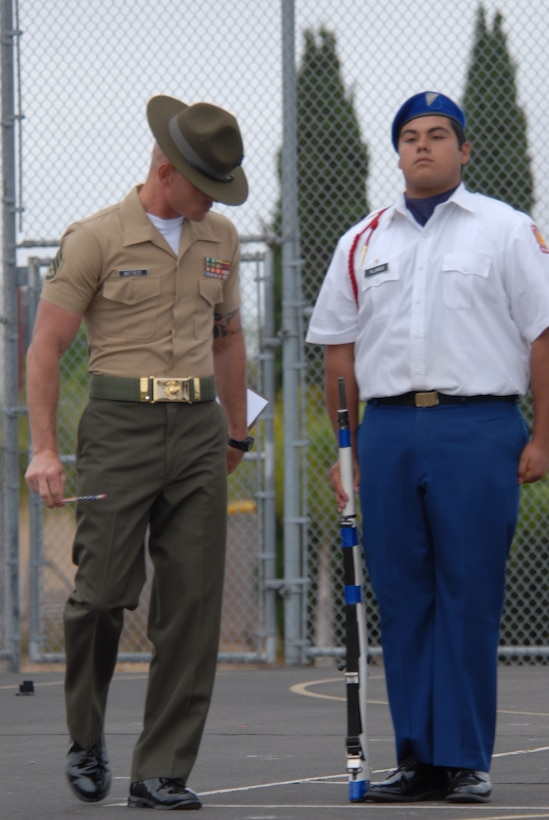 Staff Sgt. Levi Lazaro, a Company L drill instructor, inspects::r::::n::Army cadet 1st Sgt. Issac Flores before the four-man armed::r::::n::fancy drill competition began.