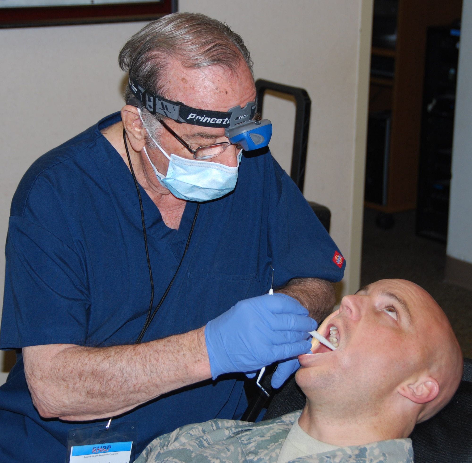 Dr. A.B. Holt, D.D.S., examines Staff Sgt. Corey Lambrecht’s teeth at a dental event at Tinker Air Force Base on April 2, 2011.  Lambrecht is from the 72nd Aerial Port Squadron.  (U.S. Air Force photo by Tech. Sgt. Zach Jacobs)