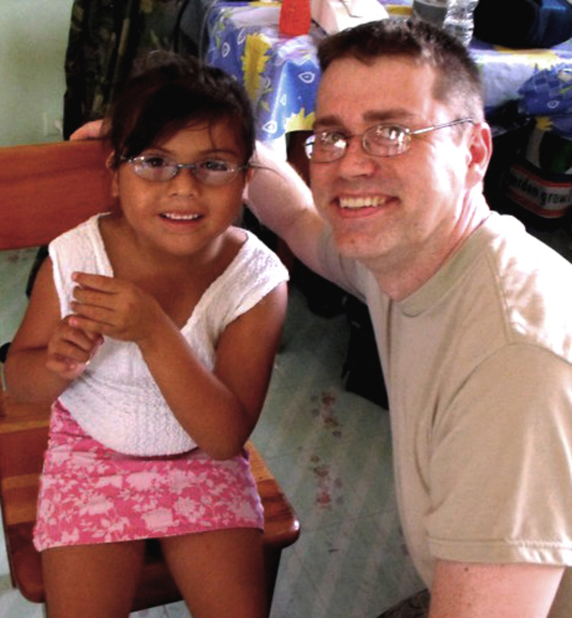 A Belizean girl poses with Master Sgt. Darrin Oglesby after she receives new eyeglasses in this undated photo.  The MEDRETE brought Air Force Reservists to Belize from March 26 to April 9, 2011, to train on real-world medical procedures and to deliver free basic medical care to local citizens.  (Air Force Photo)