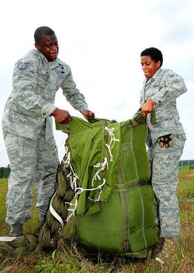 Tech. Sgt. Corey Gordon, 41st APS rigger, and Senior Airman Harriet Young, 41st APS, field pack the G-12 equipment parachute. (U.S. Air Force photo by Staff. Sgt Yolanda Addison) 


