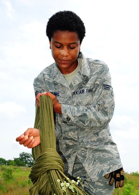 Senior Airman Harriet Young, 41st APS, daisy chains the G-12 equipment parachute for easier packing. (U.S. Air Force photo by Staff. Sgt Yolanda Addison) 
