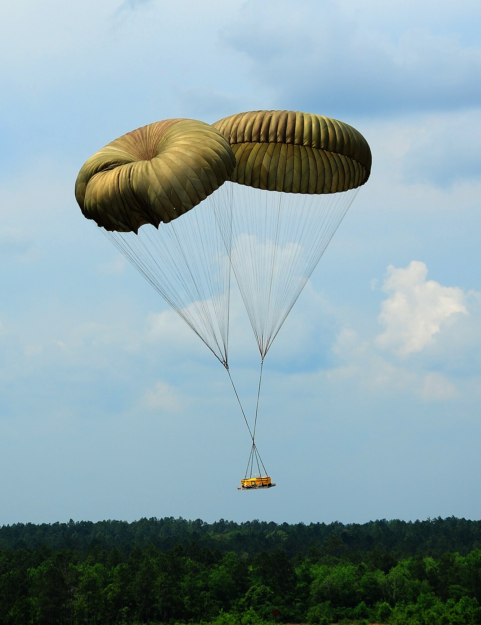 The G-12 equipment parachute packed by the 41st APS riggers drops on target. (U.S. Air Force photo by Staff. Sgt Yolanda Addison)