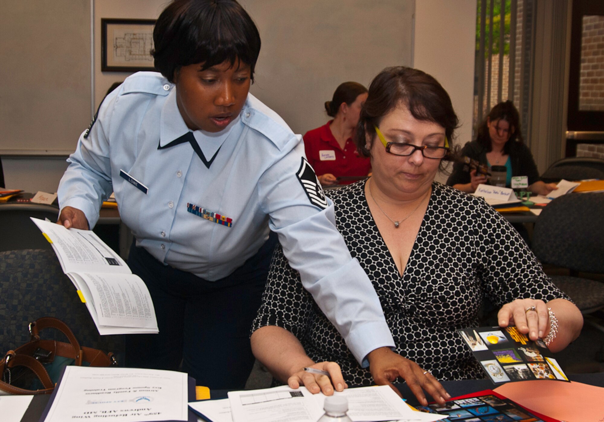 JOINT BASE ANDREWS, Md. -- Master Sgt. Charlene Lowe, 459th Force Support Squadron chief of Airmen and Family Readiness assistsJackie Edleman during an interactive exercise at the Key Spouse initial training here May 14. The Key Spouse Program at the 459th Air Refueling Wing supports Airmen and their families during deployments, separations and emergencies, as well as enhancing and encouraging regular communication between units and families. (U.S. Air Force photo/Staff Sgt. Sophia Piellusch)