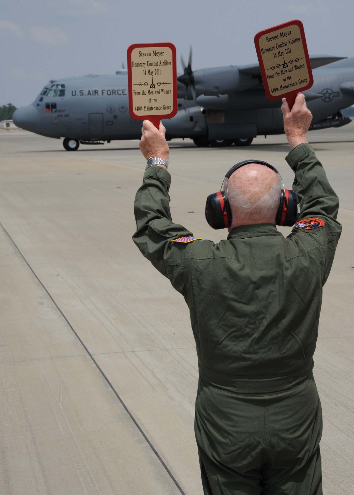 World War II veteran, Mr. Steven Meyer holds up his marshalling paddles to direct a 440th Airlift Wing C-130 aircraft into position on the Pope Field flightline.  Mr. Meyer celebrated his 89th birthday by having his “wish of a lifetime” fulfilled May 13, 2011. His wish was to stand out on a flightline and guide an aircraft into its parking spot. The event was a collaborative effort of the Heritage Raleigh Brookdale Senior Living retirement community in Raleigh, N.C., the Airmen of the 440th Airlift Wing and ‘Wish of a Lifetime,’ the foundation created by Olympic skater and former National Football League player Jeremy Bloom.   (U.S. Air Force photo by Staff Sgt. Peter R. Miller)