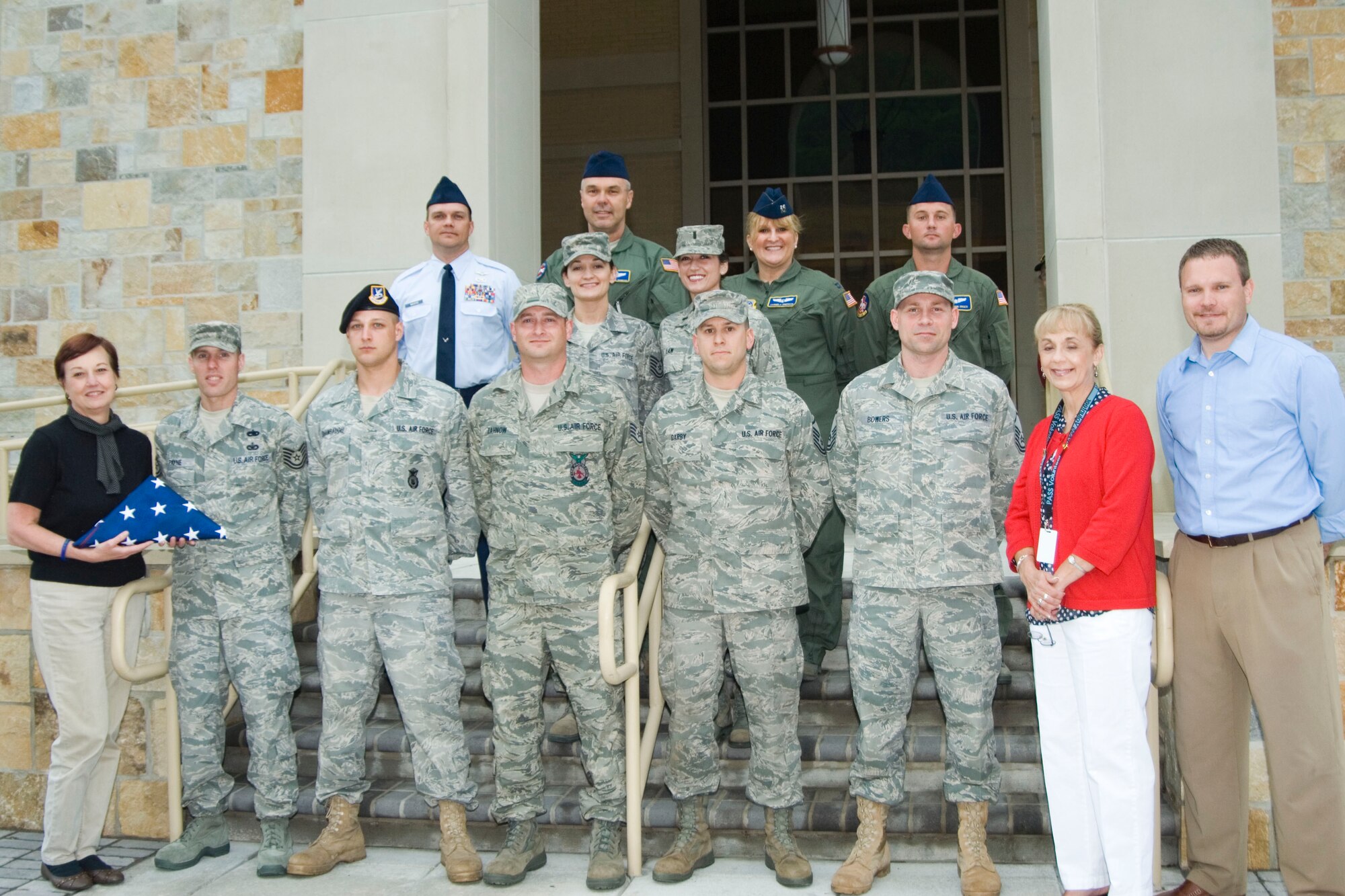 Airmen from the 167th Airlift Wing who call Morgan County home presented local officials with an American flag Saturday night to fly at the new courthouse in downtown Berkeley Springs, W.Va. Pictured in the first row, from left: Berkeley Springs Mayor Susan Webster, Tech Sgt. Sylvester Payne Jr., Staff Sgt. Luke Shambaugh, Staff Sgt. D.J. Zahnow, Master Sgt. Michael Darby, Master Sgt. Robert Bowers, Morgan County Commissioner Brenda Hutchinson and Morgan County Commissioner Brad Close. Second row, from left: Tech. Sgt. Gretchen Close and 1st Lt. Sarah Law. Third row, from left: Senior Master Sgt. Scott Wachter, Chief Master Sgt. Roland Shambaugh Jr., Capt. Carmela Emerson and Senior Airman John Unger rounding out the back row. (U.S. Air Force photo by Staff Sgt. Sherree Grebenstein)