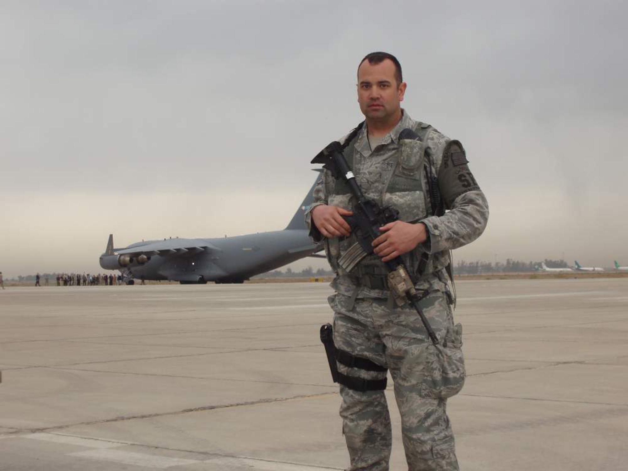Staff Sgt. Ryan Demille, 151st Security Forces Squadron, Utah Air National Guard, poses in front of a C-17 on a flightline in Iraq. Sergeant Demille is on a six-month deployment to Iraq with the 151st SFS to assist airbase defensive forces in support of Operation New Dawn. U.S. courtesy photo (Released)