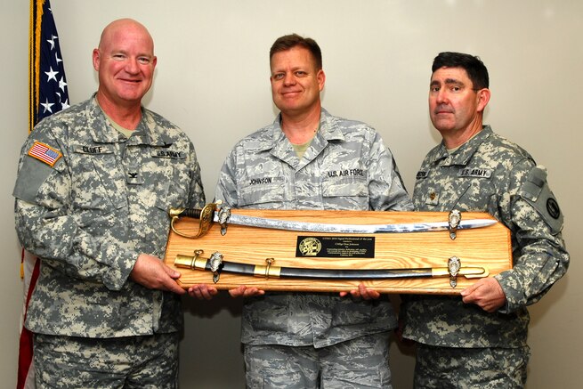 The Utah National Guard J6 Chief Information Officer, Col. Greggory Cluff, and Maj. Ben Morris, the state emergency communications manager, pose with the award winner, Chief Master Sgt. Don Johnson. Chief Johnson, a cyber systems branch chief with the 151st Communications Flight, was recently awarded the Utah National Guard?s 2010 Communications Professional of the Year. (U.S. Air Force courtesy photo)