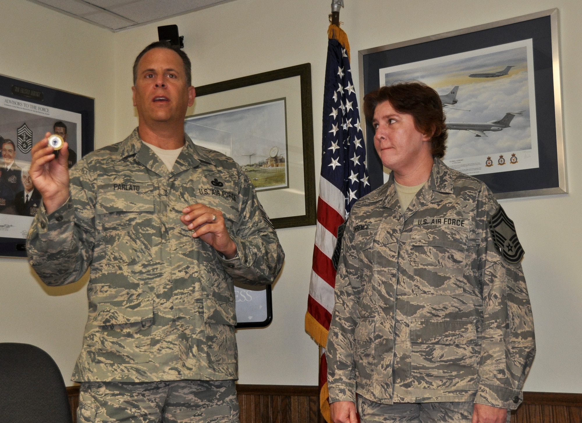 Command Chief Master Sgt. Joe Parlato, the command chief for the 128th Air Refueling Wing, presents a chief master sergeant challenge coin to Chief Master Sgt. Kelly Lawrence, the 128th Air Refueling Wing command post superintendent, on Sunday, May 15, 2011.  Lawrence was promoted to the rank of chief master sergeant on Sunday during the Wing's May drill at Gen. Mitchell International Airport, Milwaukee.