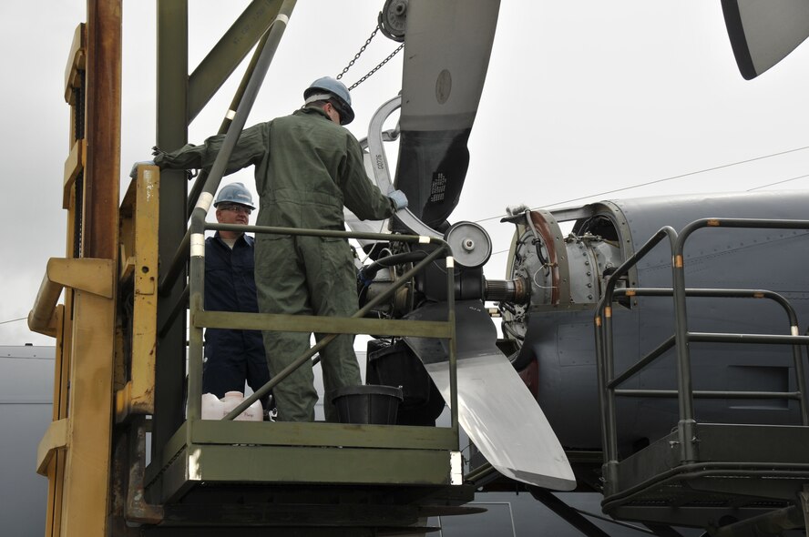 California Air National Guard Airman 1st Class Michael Soriano, left, and Staff Sgt. Brendon Baker, aerospace propulsion specialists assigned to the 129th Maintenance Squadron, remove a propeller from a MC-130P Combat Shadow at Moffett Federal Airfield, Calif., May 16, 2011. Sergeant Baker and Airman Soriano are replacing leaking seals on the aircraft. (California Air National Guard photo by Staff Sgt. Kim E. Ramirez)