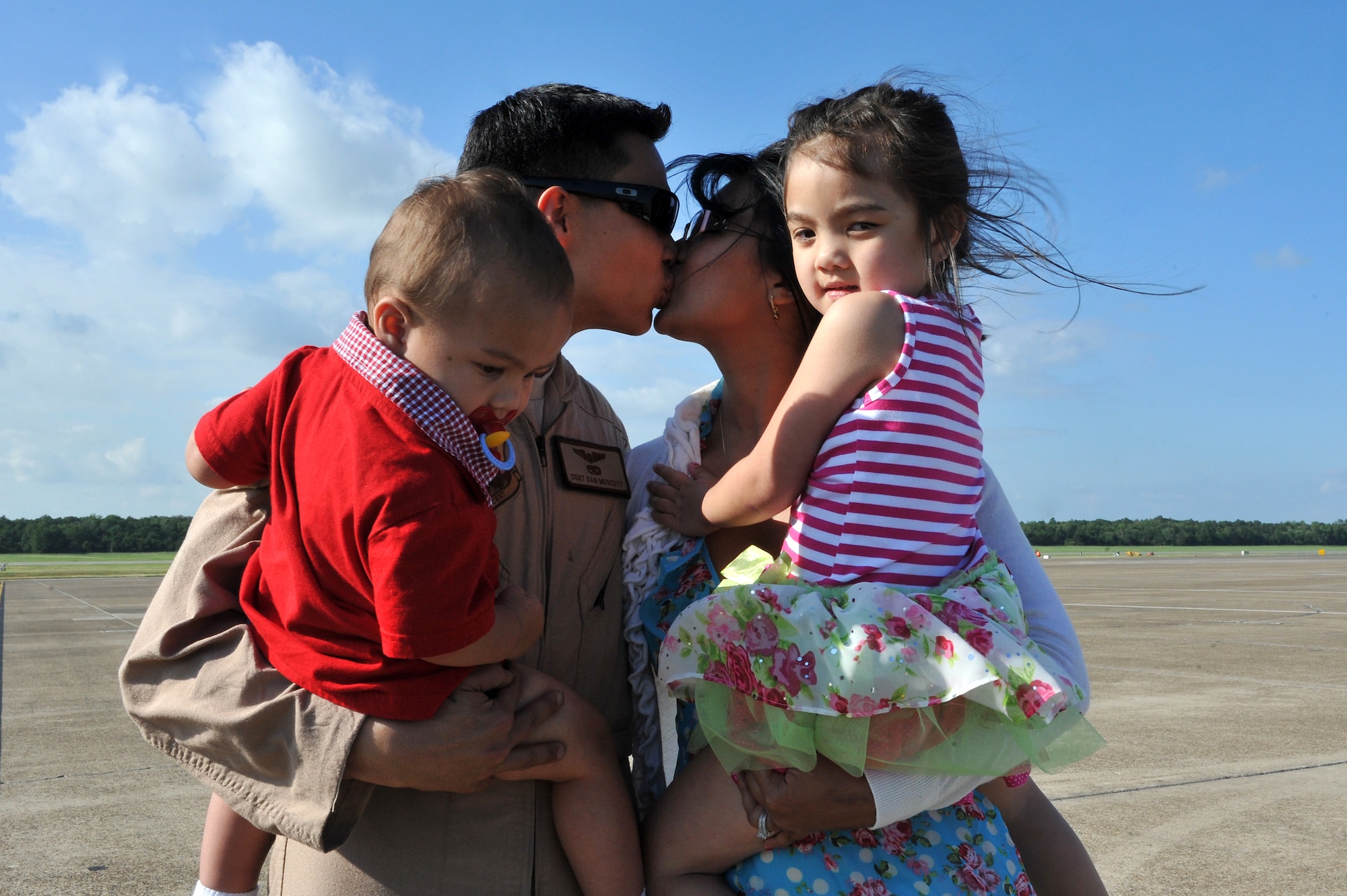 Staff Sgt. Daniel Muscutt, 61st Airlift Squadron, is welcomed home by his wife, Anjelica; son, Kai; and daughter, Adriana; on the flightline May 13, 2001, on Little Rock Air Force Base Ark.  Sergeant Muscutt and other deployed members flew missions including airdrop and aeromedical evacuation. (U.S. Air Force photo/Staff Sgt. Chris Willis)